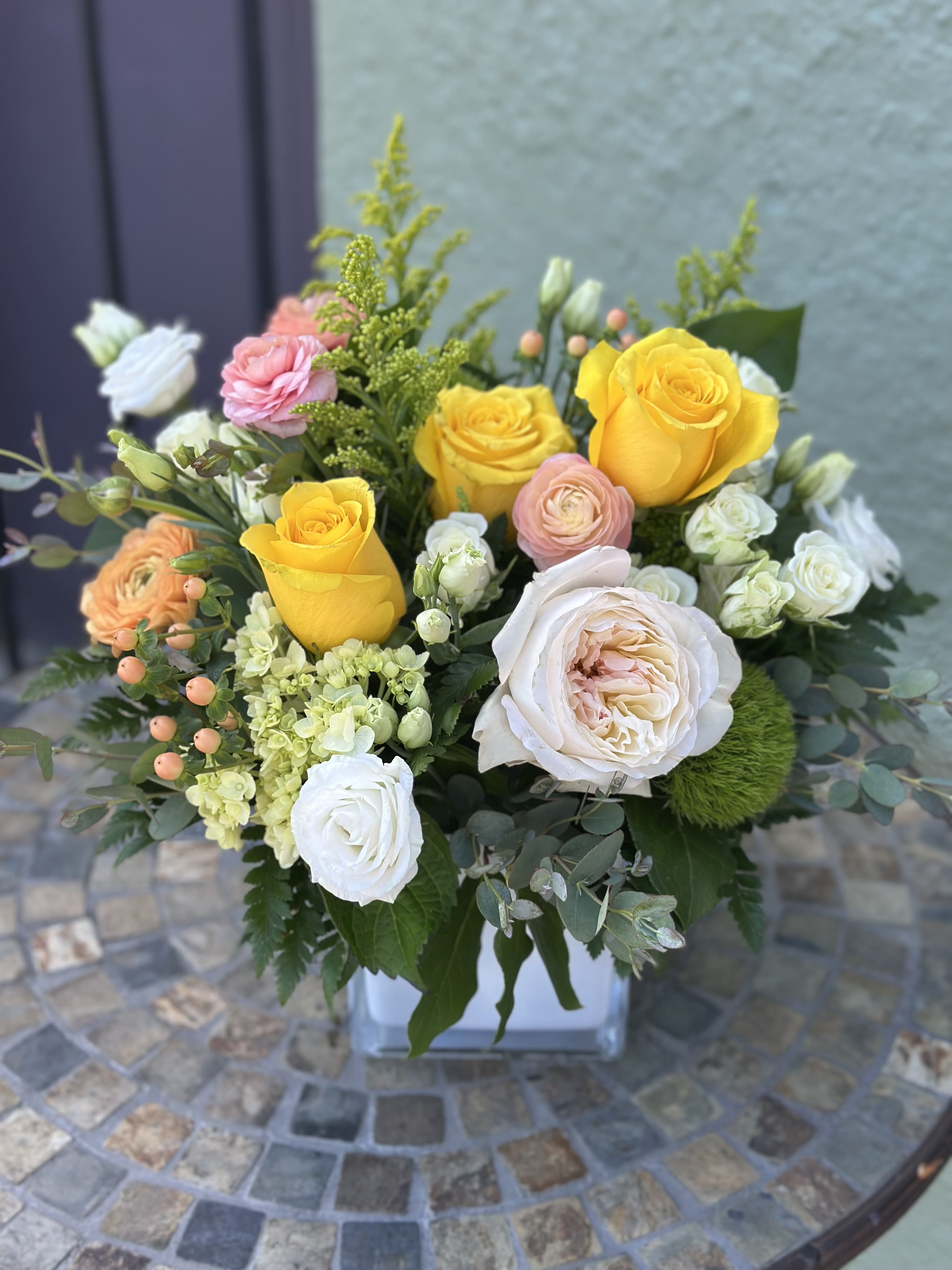 Sweet Sunbeam - Bright yellow roses take center stage in this garden-style flower arrangement, making it an ideal gift for a celebration or cheerful thank you. The sunny focal roses paired with soft white, blush pink and peach blooms create a warm, uplifting impression that will make the person you're thinking of feel noticed and celebrated.