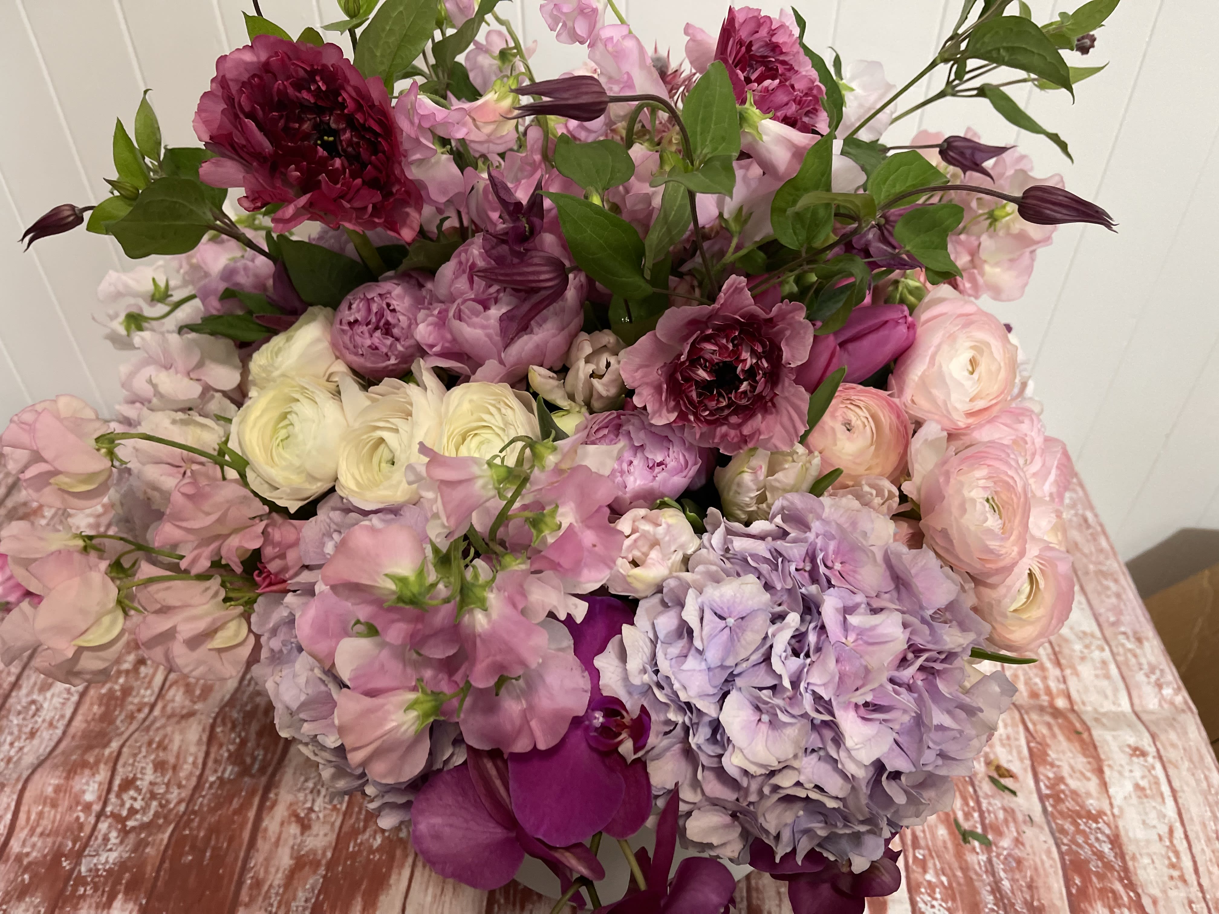 Large bouquet of pink, purple, and white flowers with green foliage