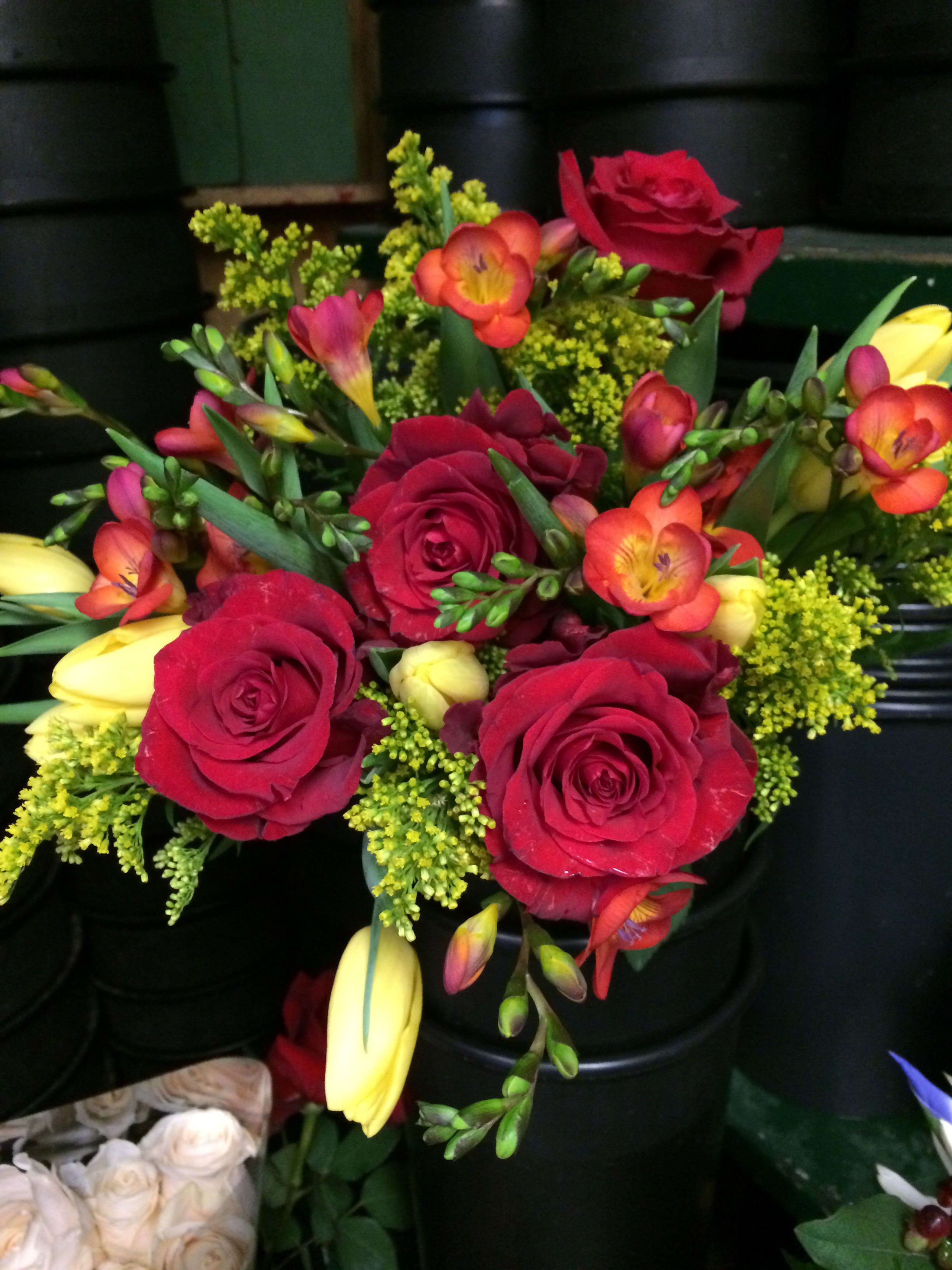 Bouquet of red roses with yellow and orange freesia