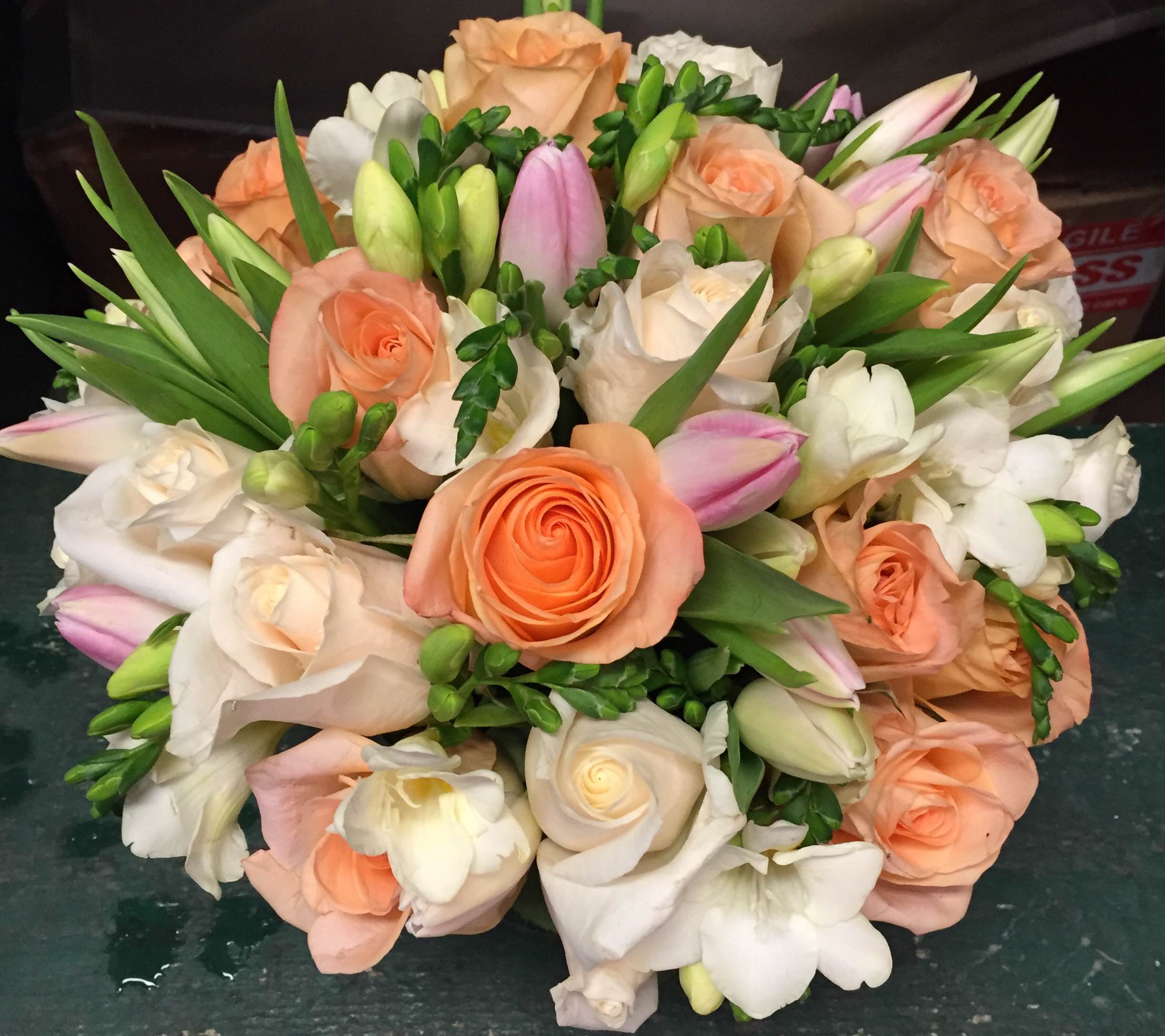 Bouquet of peach and white roses with pink tulips