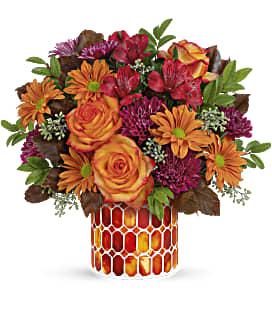 Bouquet of orange and red flowers in a patterned vase