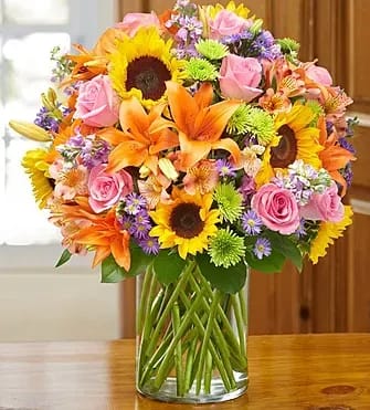 Garden of Grandeur 91351 - Product ID: 91351  Luxurious and lasting. And able to transform any celebration into the must-attend gala of the season. A grand gathering of roses, lilies, sunflowers, stock, alstroemeria and more, beautifully hand-arranged by our expert florists in a posh cylinder vase. Abundant arrangement of roses, lilies, sunflowers, stock, alstroemeria, poms and monte casino, gathered with fresh salal Beautifully designed by our expert florists in an elegant glass cylinder vase; measures 8"H Large arrangement measures approximately 22"H x 17"W Medium arrangement measures approximately 21.5"H x 16.5"W Small arrangement measures approximately 21"H x 16"W Our florists hand-design each arrangement, so colors, varieties, and basket may vary due to local availability Lilies may arrive in bud form and will open to full beauty over the next 2-3 days