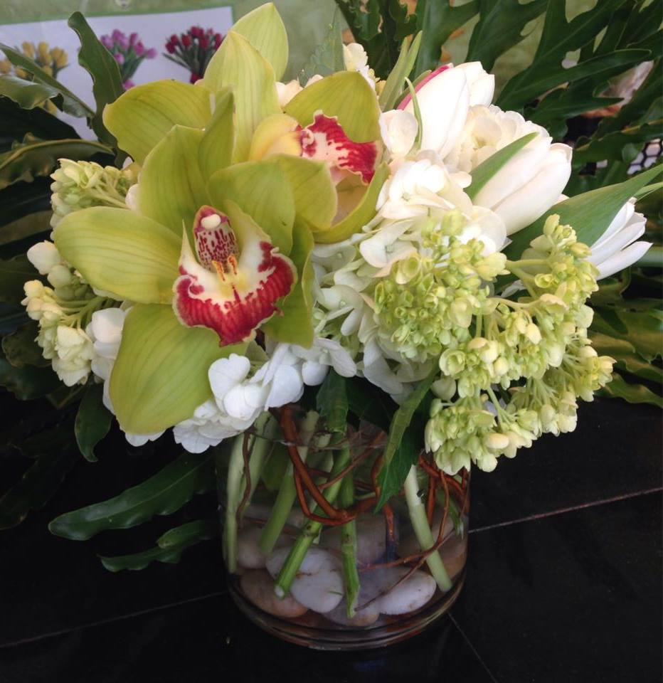 Green and white orchid arrangement in a glass vase