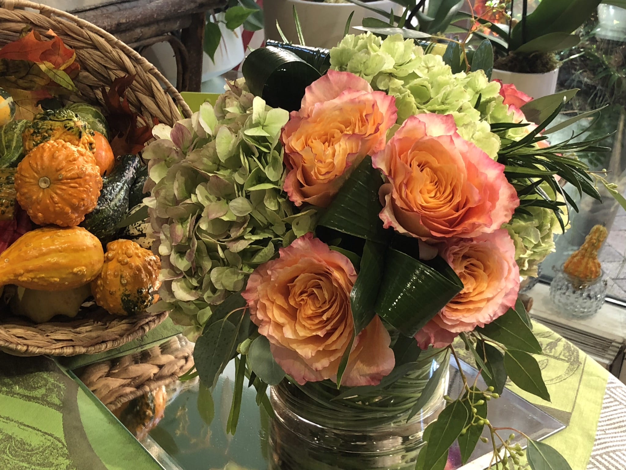 Peach roses and pale green hydrangeas in a glass vase