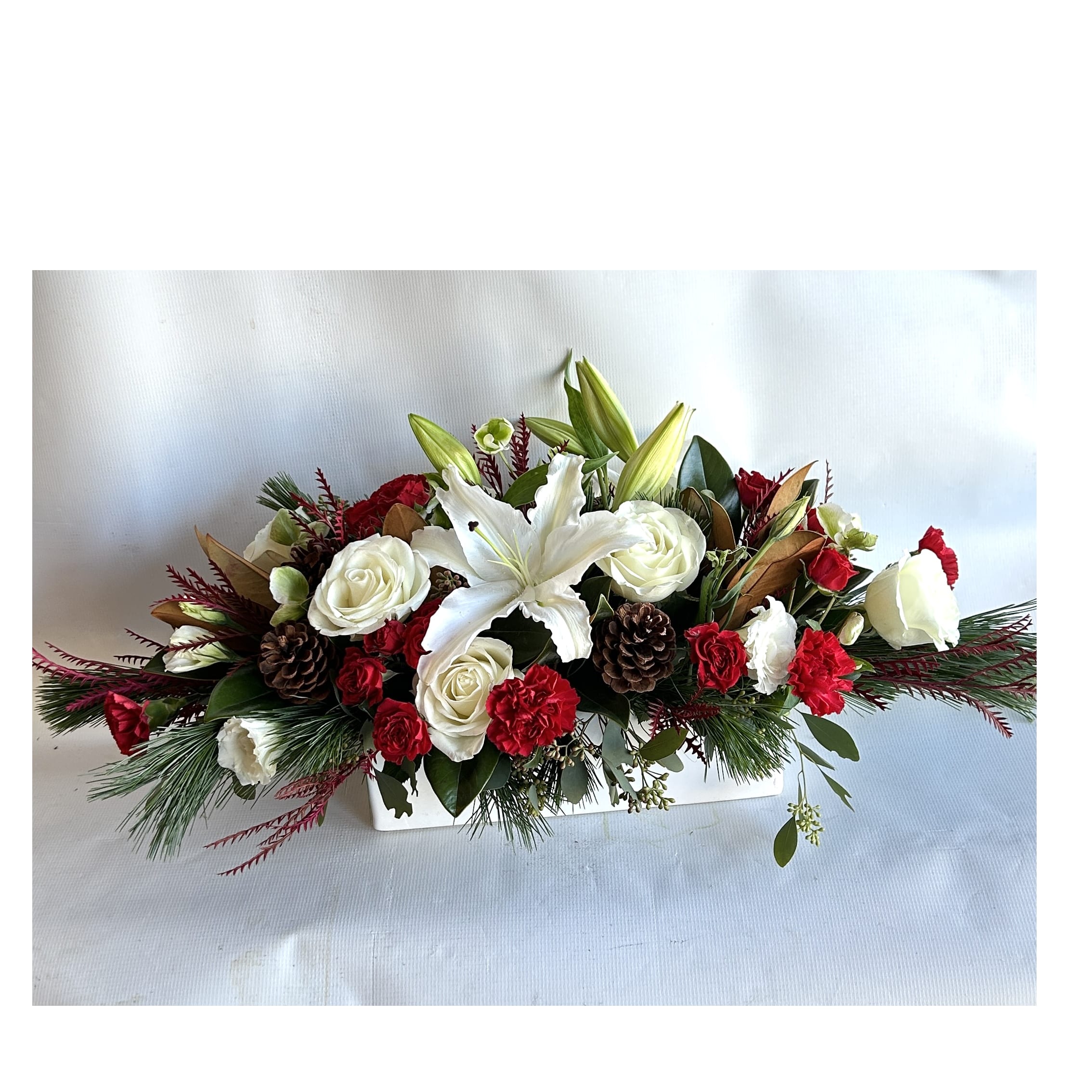 Holiday Centerpiece - A Holiday arrangement with red roses, orchids, hanging amaranthus, stargazer lilies, dianthus, and a merry holiday touch.