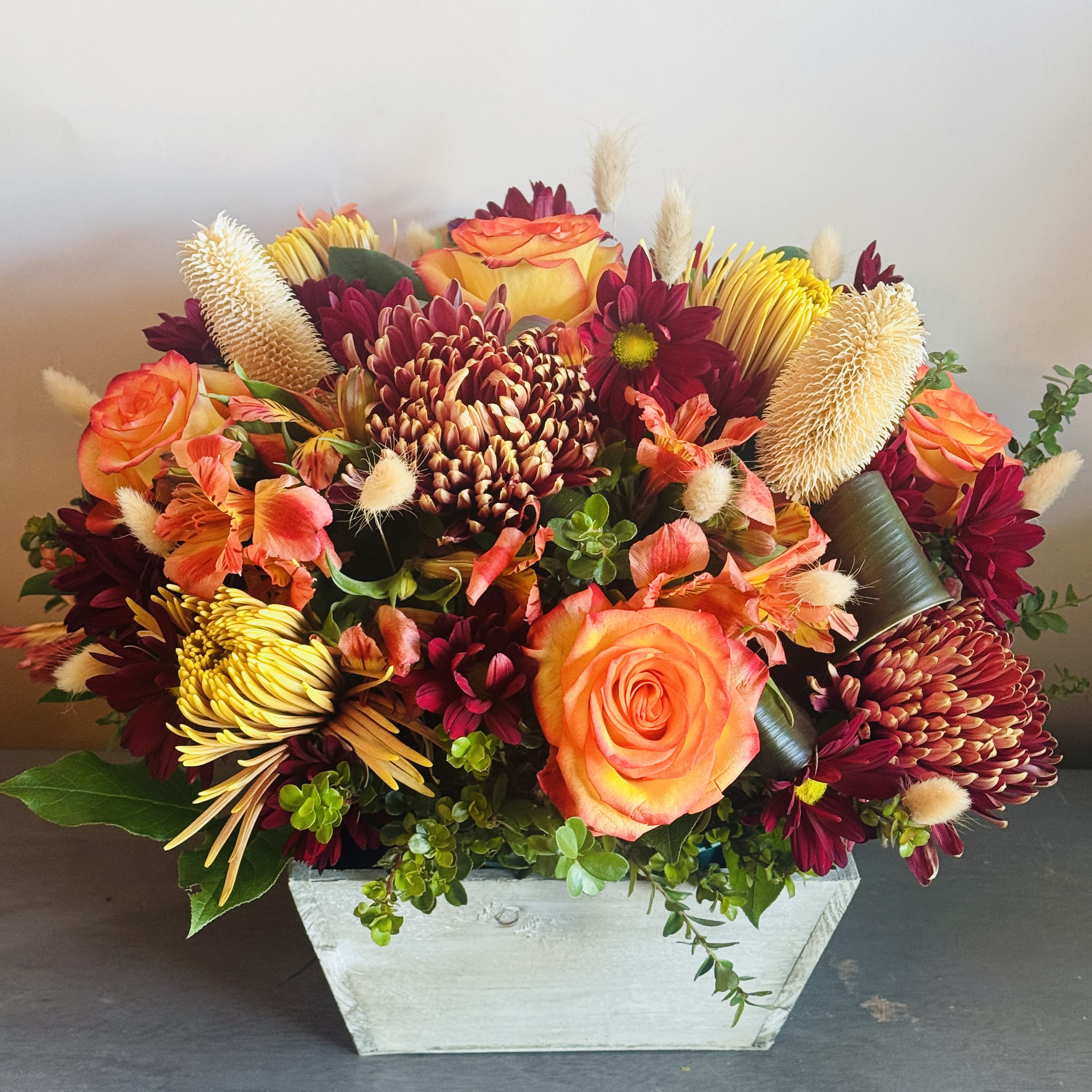Harvest Moon - A fall inspired arrangement with lilies, sunflowers, roses, stem roses, hypericum berries and billy balls.