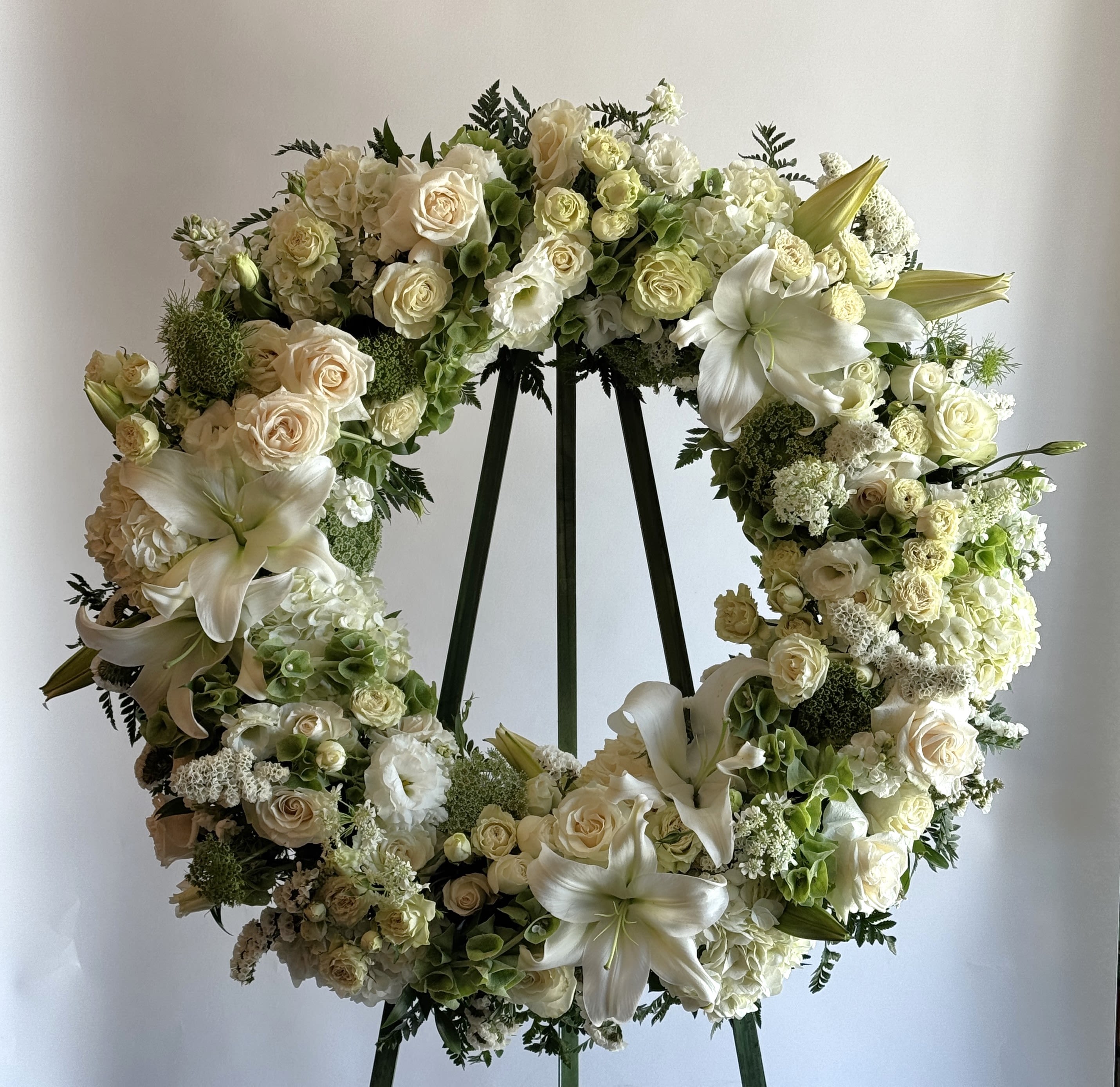 Heavenly Wreath  - A white wreath filled with Star gazer lilies, lisianthus, roses, and bells of Ireland. 