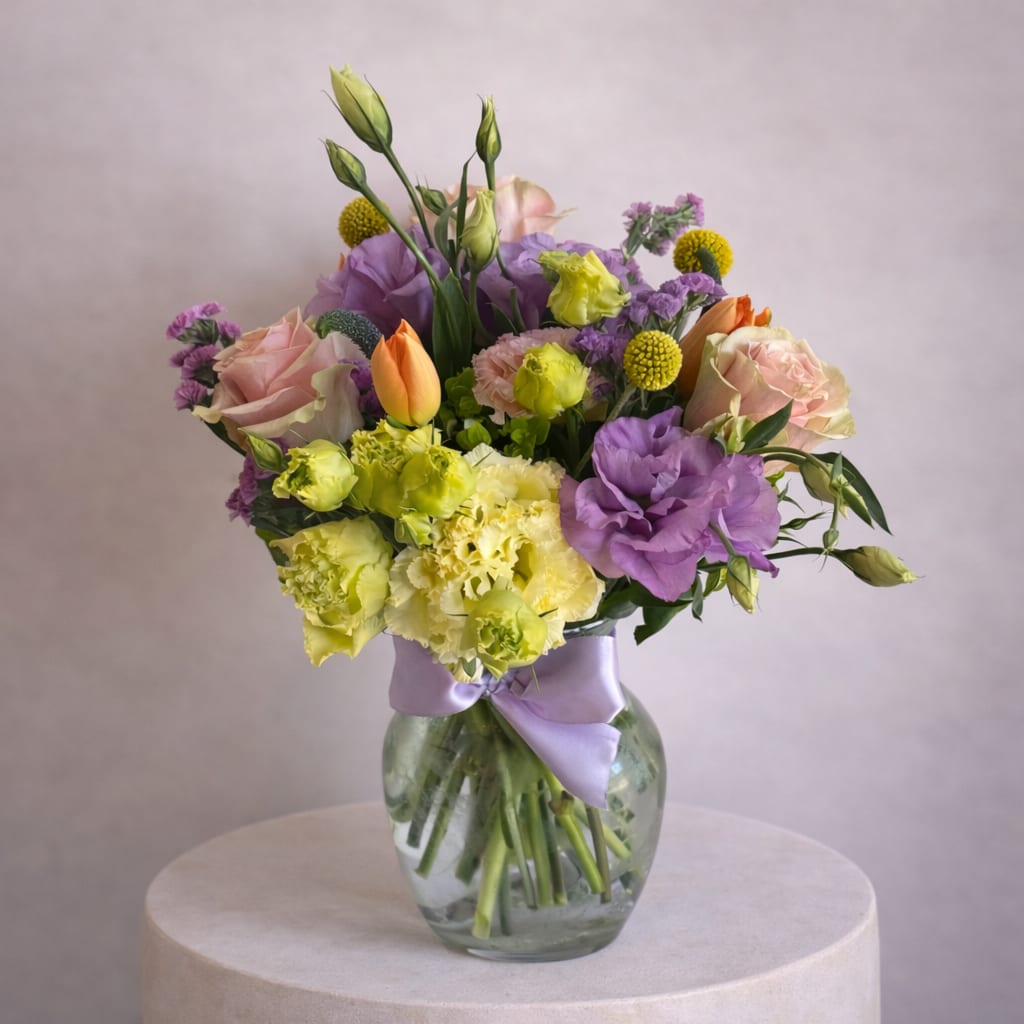 Sugarplum Dreams - This cheerful and refined floral arrangement is a lively mix of color and texture, blending the elegance of roses, the grace of lisianthus, and the charm of tulips. 