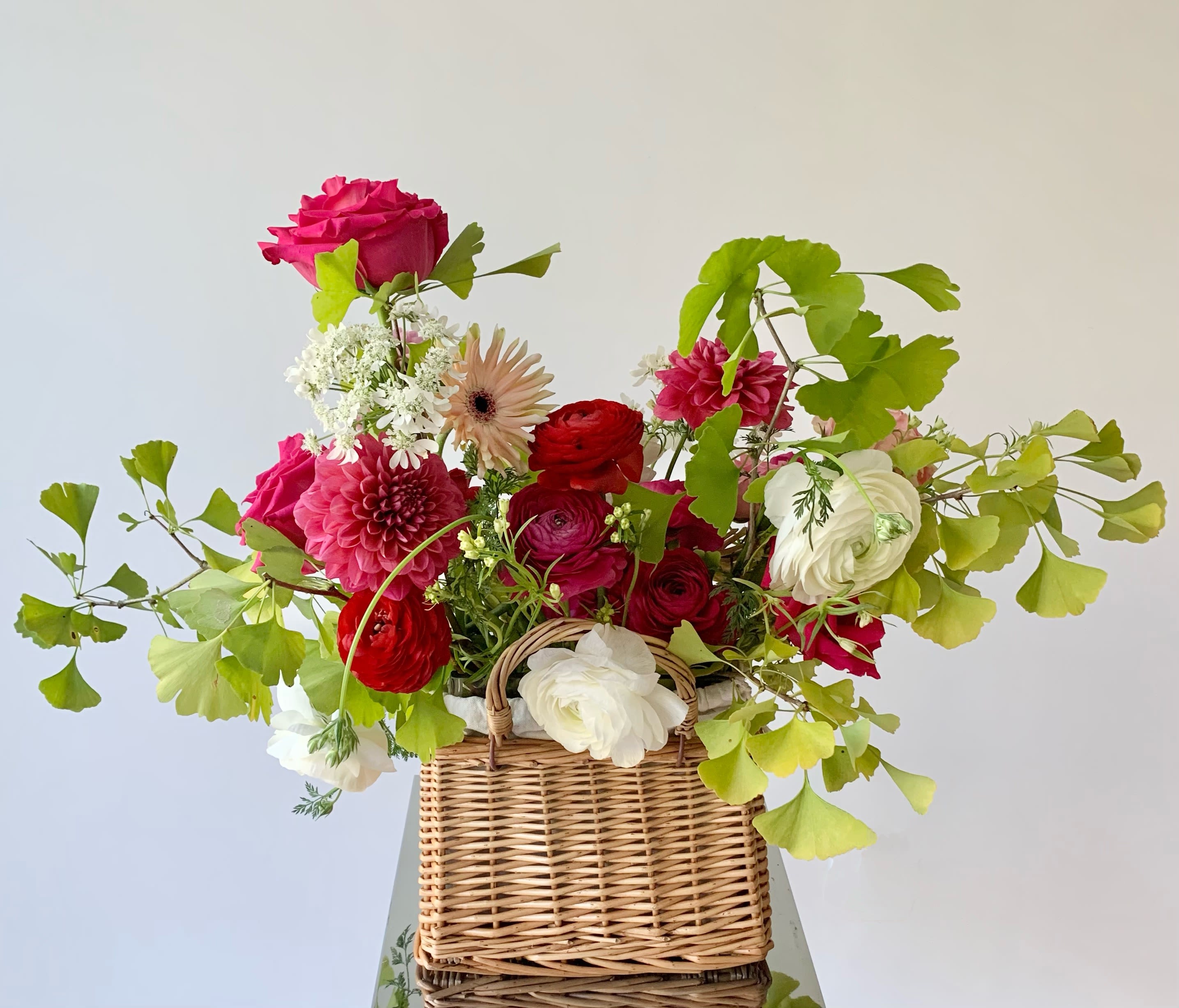 Blooming Basket - Medium - An artfully created arrangement in a rattan woven basket is a perfect flower gift for your special someone. Michaela carefully selects premium flowers in colors that speak of love and care and interesting foliage with movement and drama. Should you have any preference for a color palette, please leave a note to our designer.
