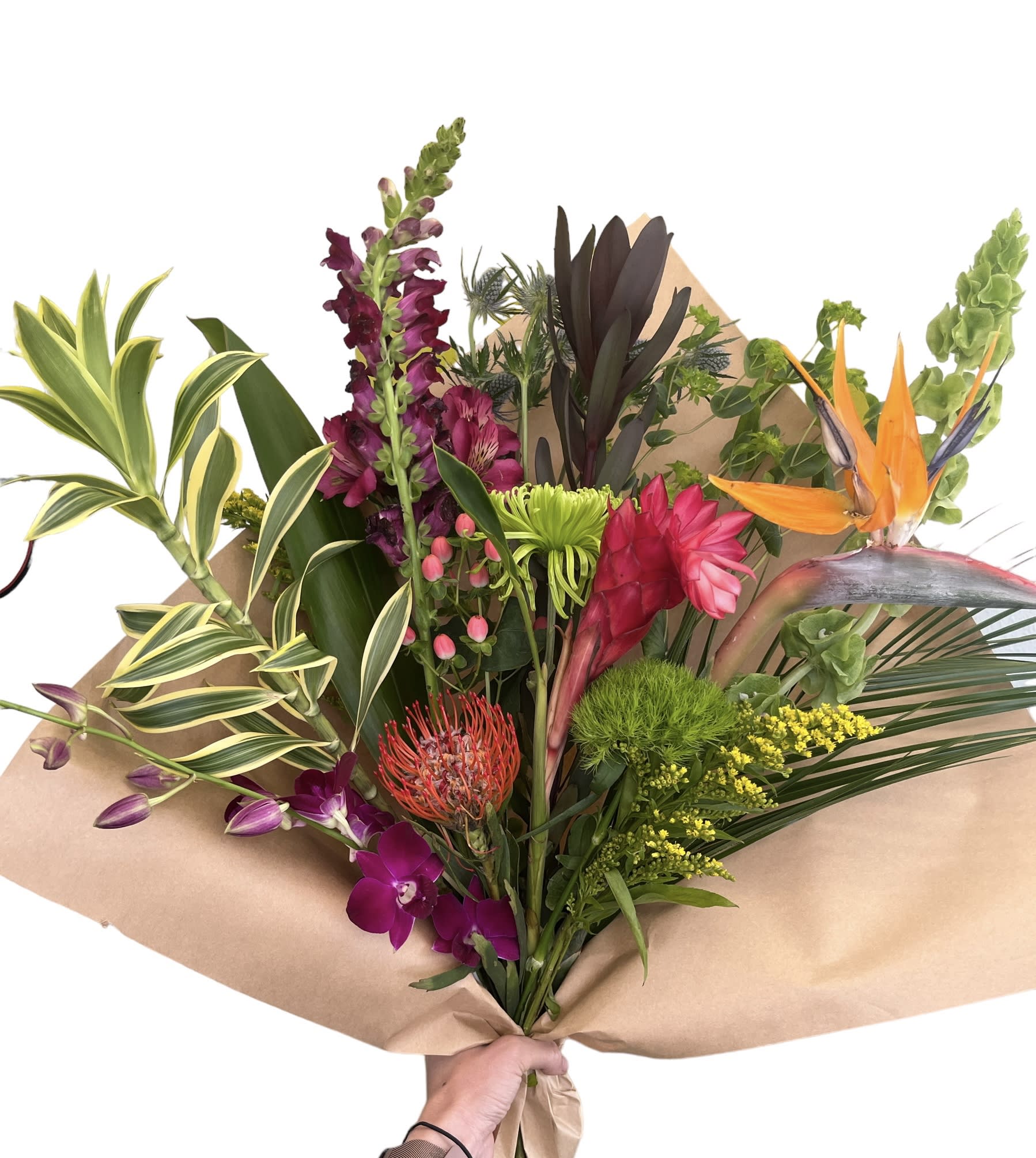 Tropical bouquet with orchids, bird of paradise, and snapdragons wrapped in kraft paper