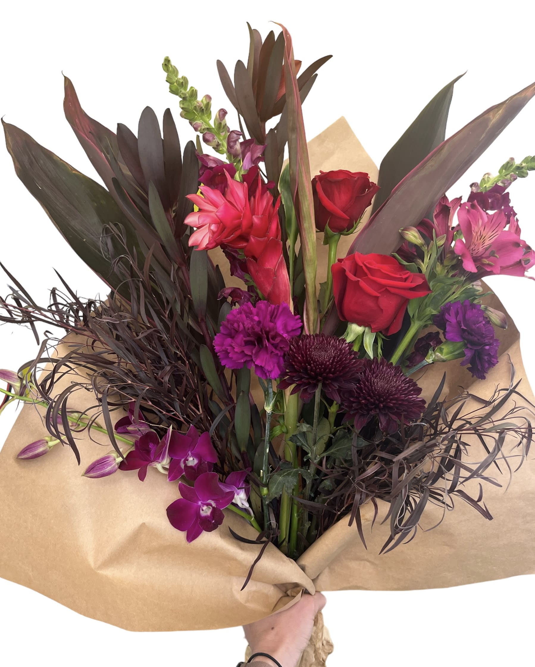 Bouquet of red roses, purple orchids, and dark foliage wrapped in kraft paper