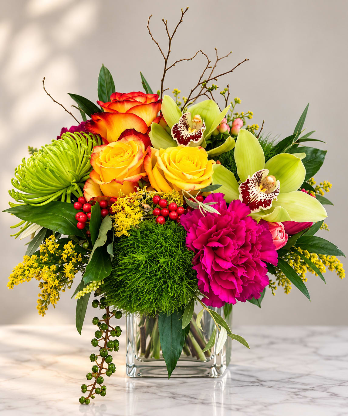 Colorful bouquet in a clear glass vase with roses, orchids, and carnations