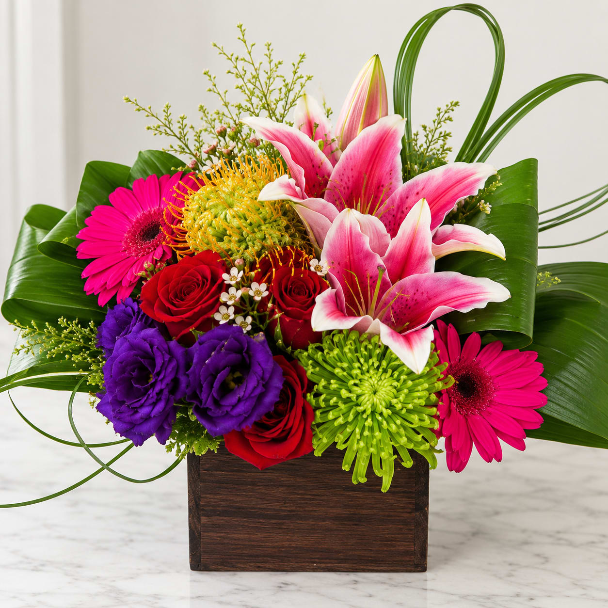 Colorful bouquet with lilies, roses, gerbera daisies, and chrysanthemums in a wooden box