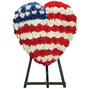 Heart-shaped red, white, and blue floral standing tribute on an easel