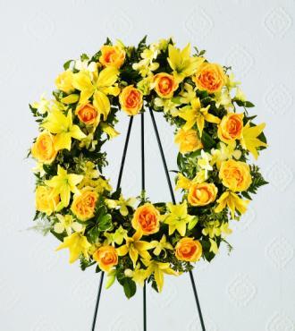 Yellow and orange floral wreath on a black stand