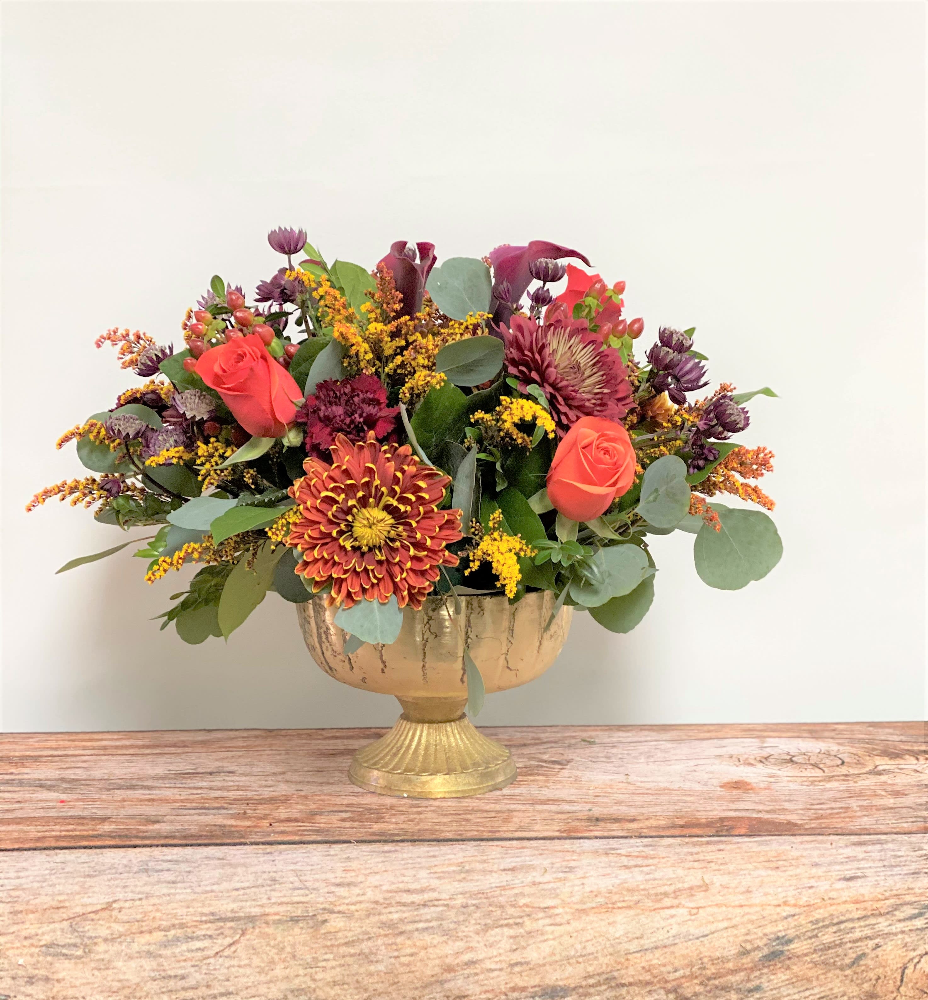 Mixed bouquet in a gold pedestal vase with roses and chrysanthemums