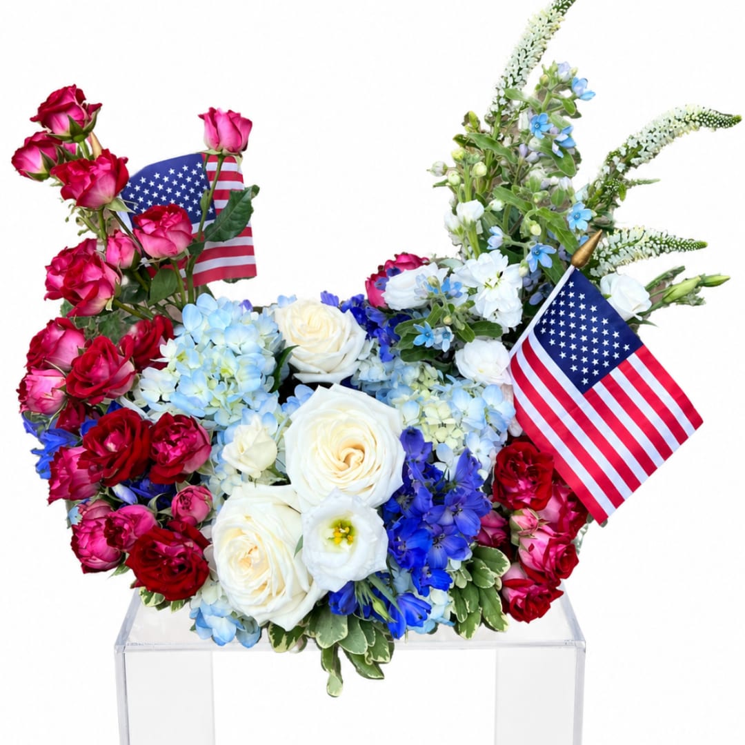 Red, white, and blue rose arrangement with two small American flags