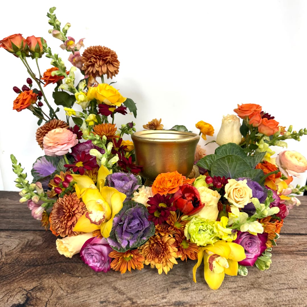 Colorful floral centerpiece with a gold candle holder in the middle