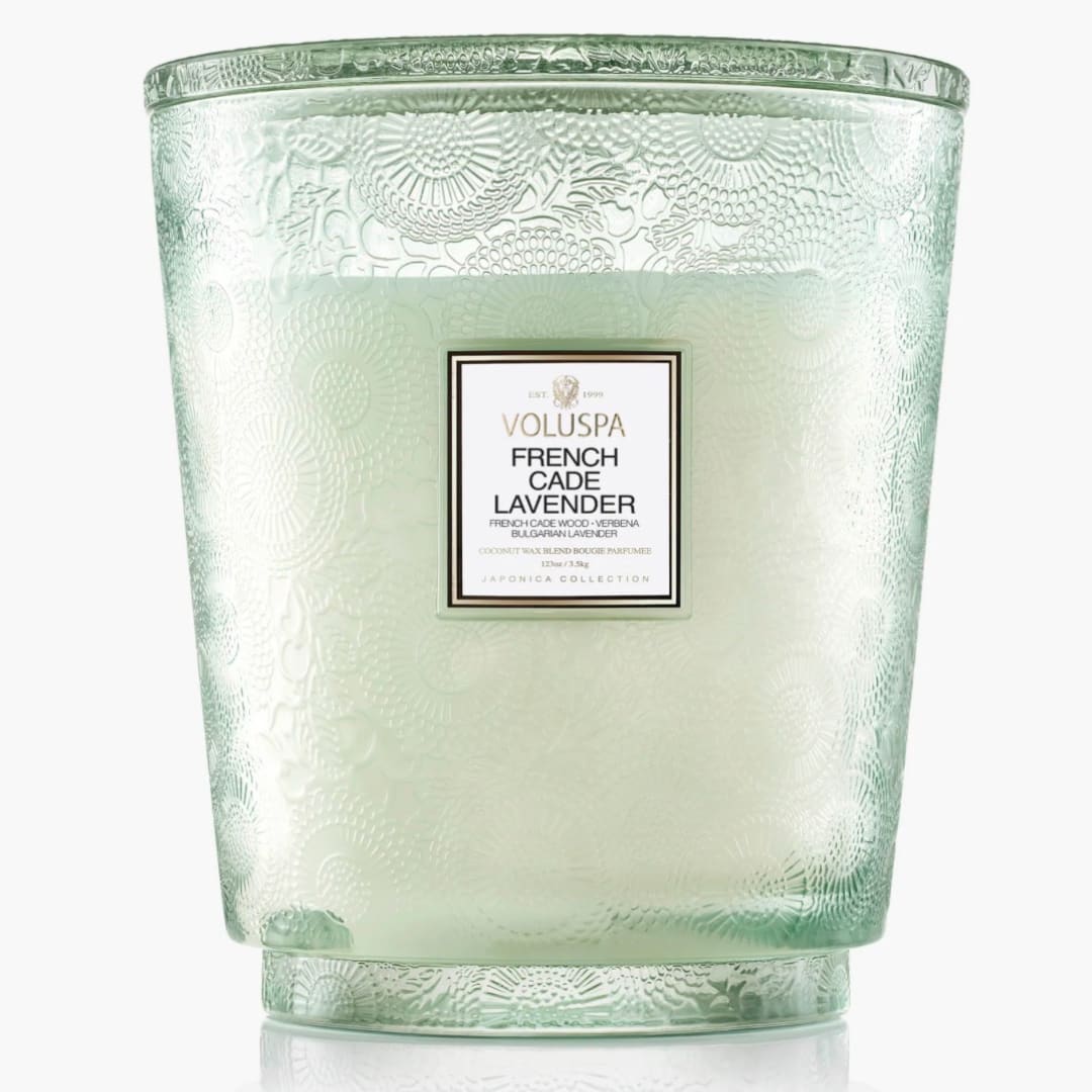 Green glass candle jar with a Voluspa French Cade Lavender label