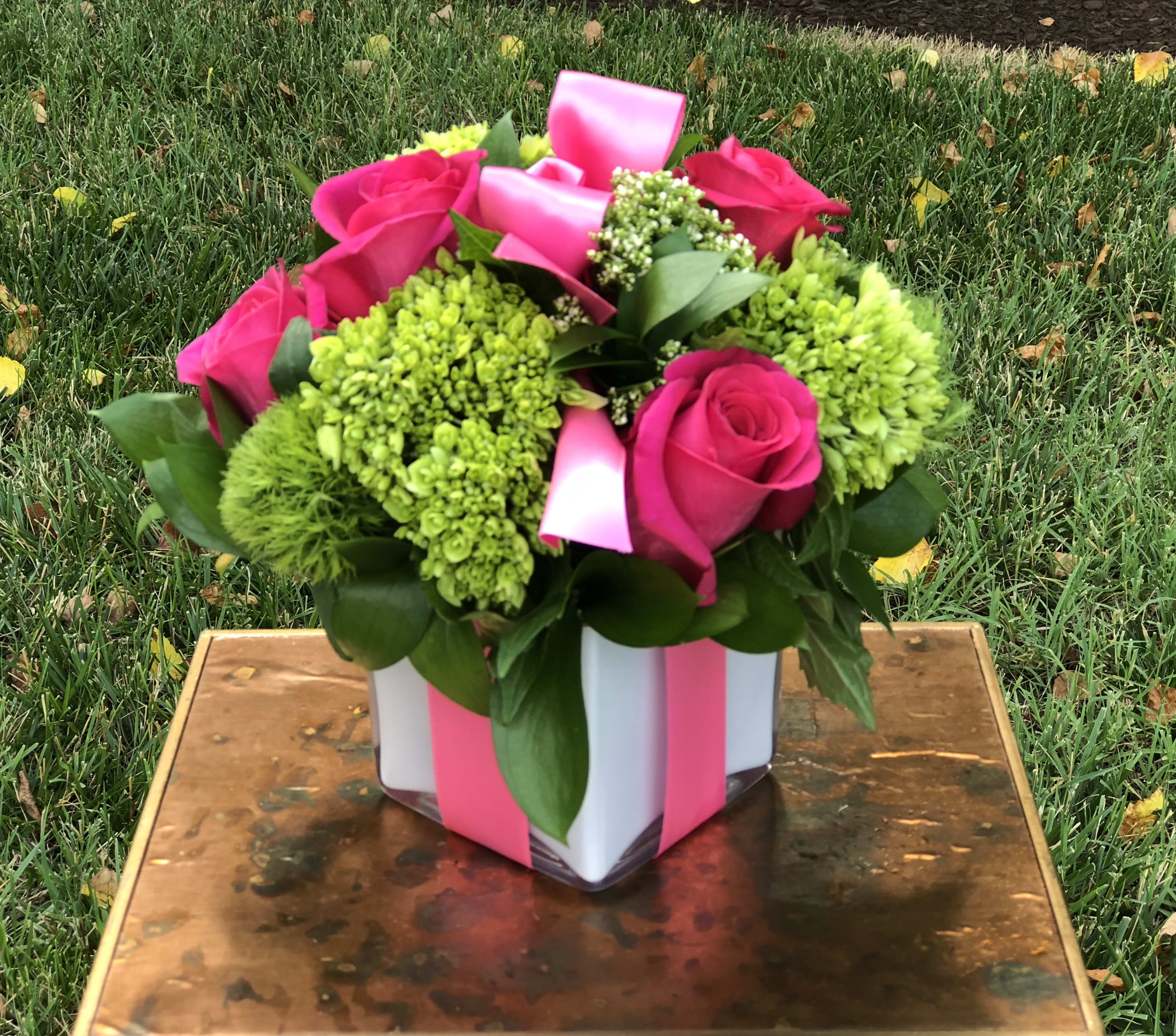 A Gift For Her - Surprise someone special with A Gift for Her, a stunning floral arrangement exclusively designed by Petals Flowers and Fine Gifts — your trusted local florist in Wilmington, Delaware. This gorgeous design features rich dark pink roses, lush green hydrangea, and playful green trichelium, all artfully arranged in a modern white cube container. Finished with a dark pink ribbon tied like a beautifully wrapped present, A Gift for Her is the perfect way to show your love, appreciation, or celebrate life’s joyful moments.  Ideal for birthdays, anniversaries, promotions, or simply to brighten her day, this vibrant mix of colors and textures brings a fresh, sophisticated feel to any space.  At Petals Flowers and Fine Gifts, we specialize in creating custom, luxury floral designs with premium flowers and exceptional attention to detail. As a local florist in Wilmington, Delaware, we proudly offer same-day, tax-free flower delivery throughout Wilmington, Hockessin, Newark, Glen Mills, Chadds Ford, Kennett Square, and surrounding areas — all backed by our satisfaction guarantee.  Why Choose Us?  * Locally owned Wilmington florist known for creativity, quality, and personalized service * Hand-crafted floral arrangements tailored to every occasion * Reliable same-day delivery to homes, offices, and venues throughout the area Order A Gift for Her today and let Petals Flowers and Fine Gifts deliver a beautiful expression of your sentiments right to her doorstep in Wilmington, Delaware.
