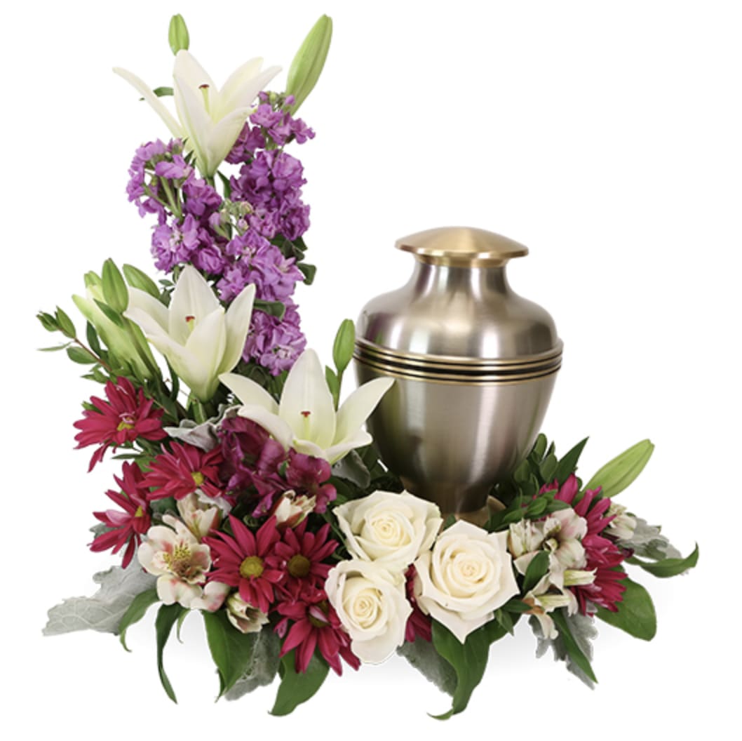 All-Encompassing Love Urn Wreath - All-Encompassing Love Urn Wreath | Wilmington, Delaware Florist  Surround your loved one in beauty and grace with our All-Encompassing Love Urn Wreath, a touching floral tribute by Petals Flowers and Fine Gifts in Wilmington, Delaware. This elegant design features a rich blend of white lilies, white roses, lavender stock, and burgundy blooms, artfully arranged to cradle an urn with dignity and care. Wreath measures 12" in diameter.  With a harmonious balance of soft and vibrant tones, All-Encompassing Love reflects the depth of your devotion and the warmth of cherished memories. This arrangement is thoughtfully designed for memorial services and cremation ceremonies, offering a heartfelt expression of eternal love and reverence.  As your trusted local florist in Wilmington, Delaware, we take pride in crafting every design with premium blooms and personal attention. We offer same-day, tax-free delivery throughout Wilmington, Hockessin, Newark, Chadds Ford, Glen Mills, Kennett Square, and surrounding communities.  Why Choose Us?  * Custom, luxury floral designs with a satisfaction guarantee * Locally owned flower shop in North Wilmington, Delaware * Friendly, personal service with delivery to your loved ones’ doorsteps Send the All-Encompassing Love Urn Wreath to honor a beautiful life with a floral embrace as timeless as your memories across Wilmington and the surrounding area.