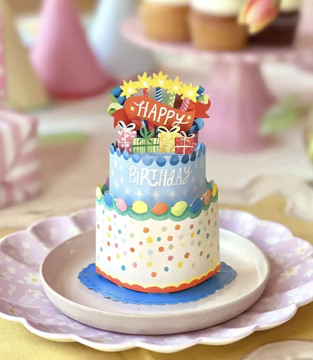 Decorative birthday cake centerpiece with colorful paper toppers