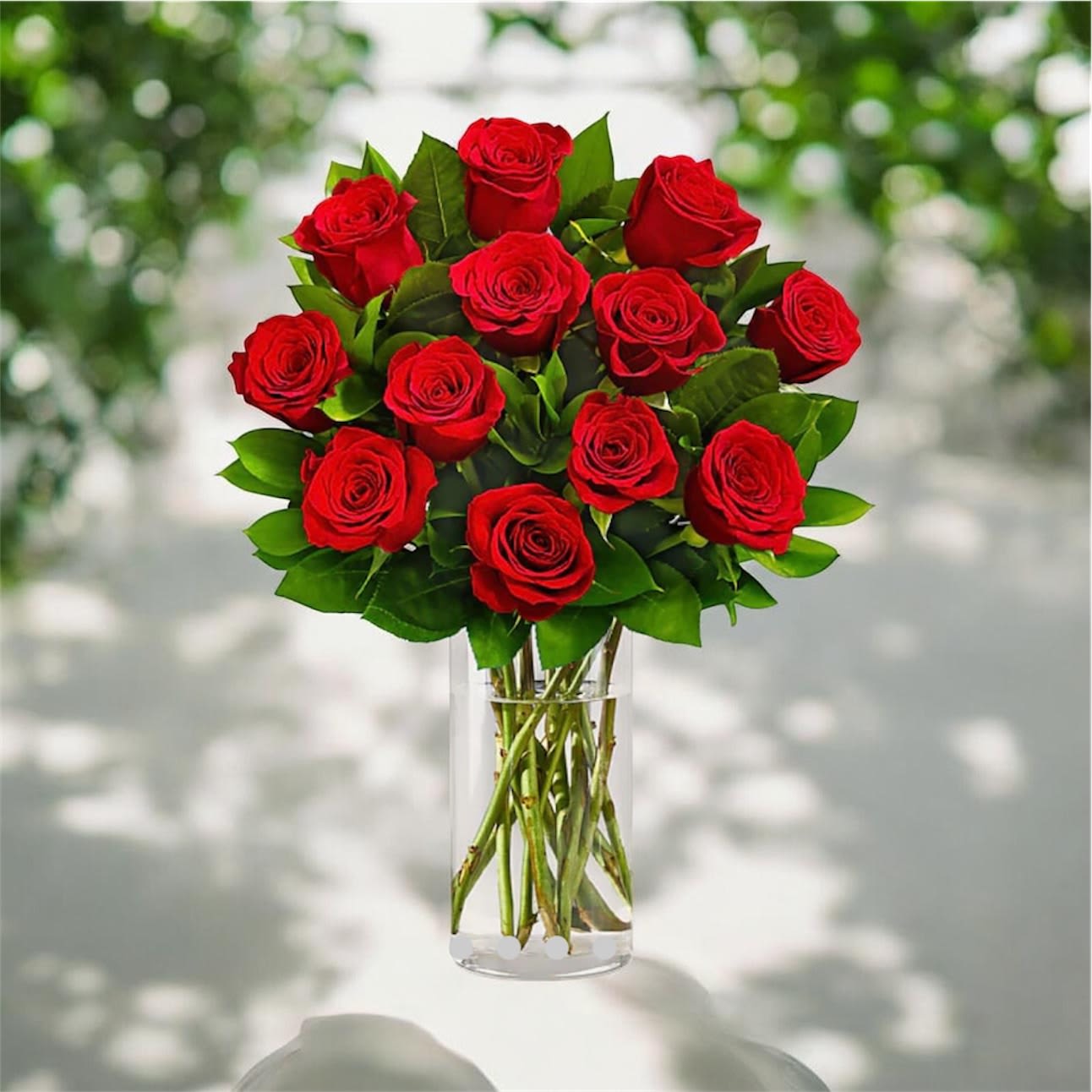 One Dozen Roses - One Dozen Roses in a Vase – Wilmington, DE Flower Delivery Make a timeless statement with a stunning arrangement of one dozen fresh roses, artfully designed in a classic glass vase and accented with lush seasonal greenery. Perfect for anniversaries, birthdays, romantic surprises, or just because, this elegant bouquet delivers beauty and meaning in every stem. Our expert florists in Wilmington, Delaware carefully select premium roses to ensure vibrant color, long-lasting freshness, and a luxurious presentation. Each arrangement is hand-crafted and ready to impress from the moment it arrives. What’s Included: 12 fresh, hand-selected roses Elegant vase for a polished presentation Complementary greenery for a full, balanced look Delivery Details: Red roses are the standard selection and will be delivered unless a different color is requested at checkout. Same-day and next-day flower delivery available throughout Wilmington, DE and surrounding areas. Whether you’re celebrating love or sending a heartfelt gesture, this classic dozen roses arrangement is a beautiful way to say it all.