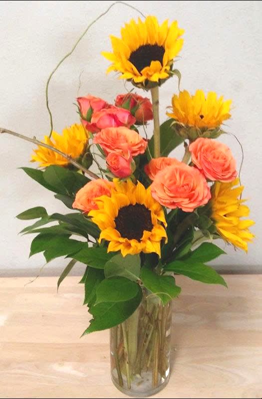 Sunflowers and peach roses in a clear glass vase