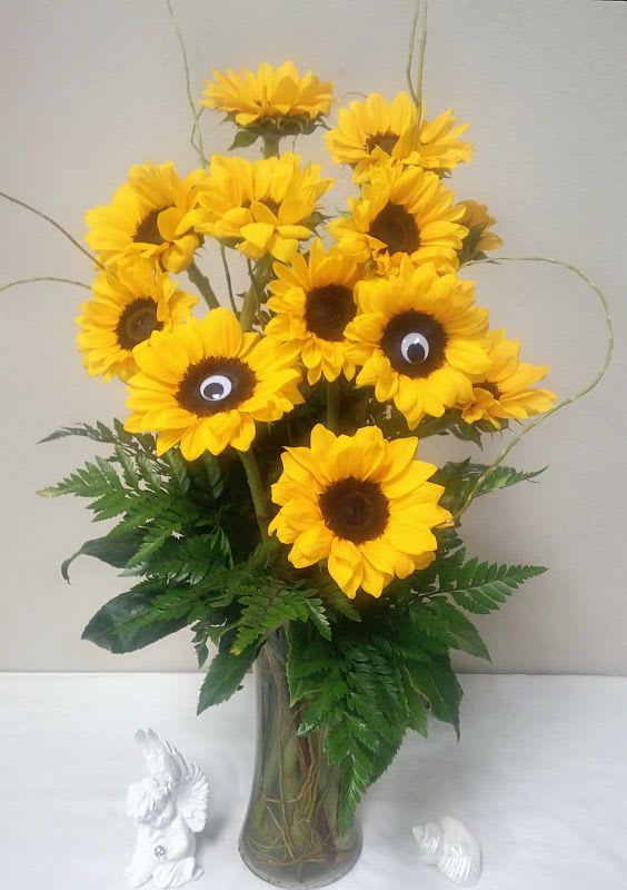 Sunflower bouquet in a glass vase with decorative googly eyes