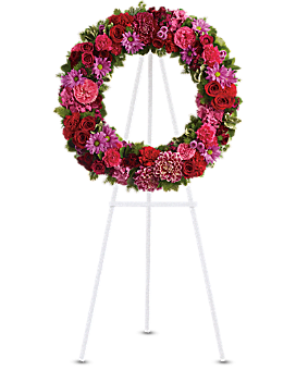 Pink and red floral wreath on a white easel