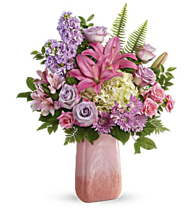 Pink lilies and lavender flowers in a tall pink vase