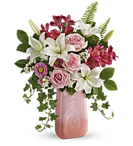 Pink and white floral arrangement in a tall pink vase