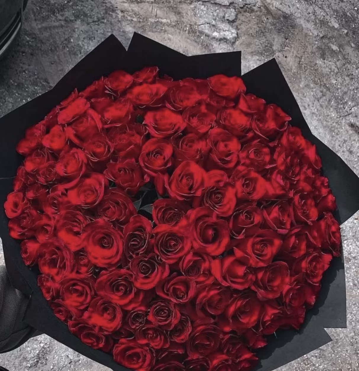 Large bouquet of red roses wrapped in black paper