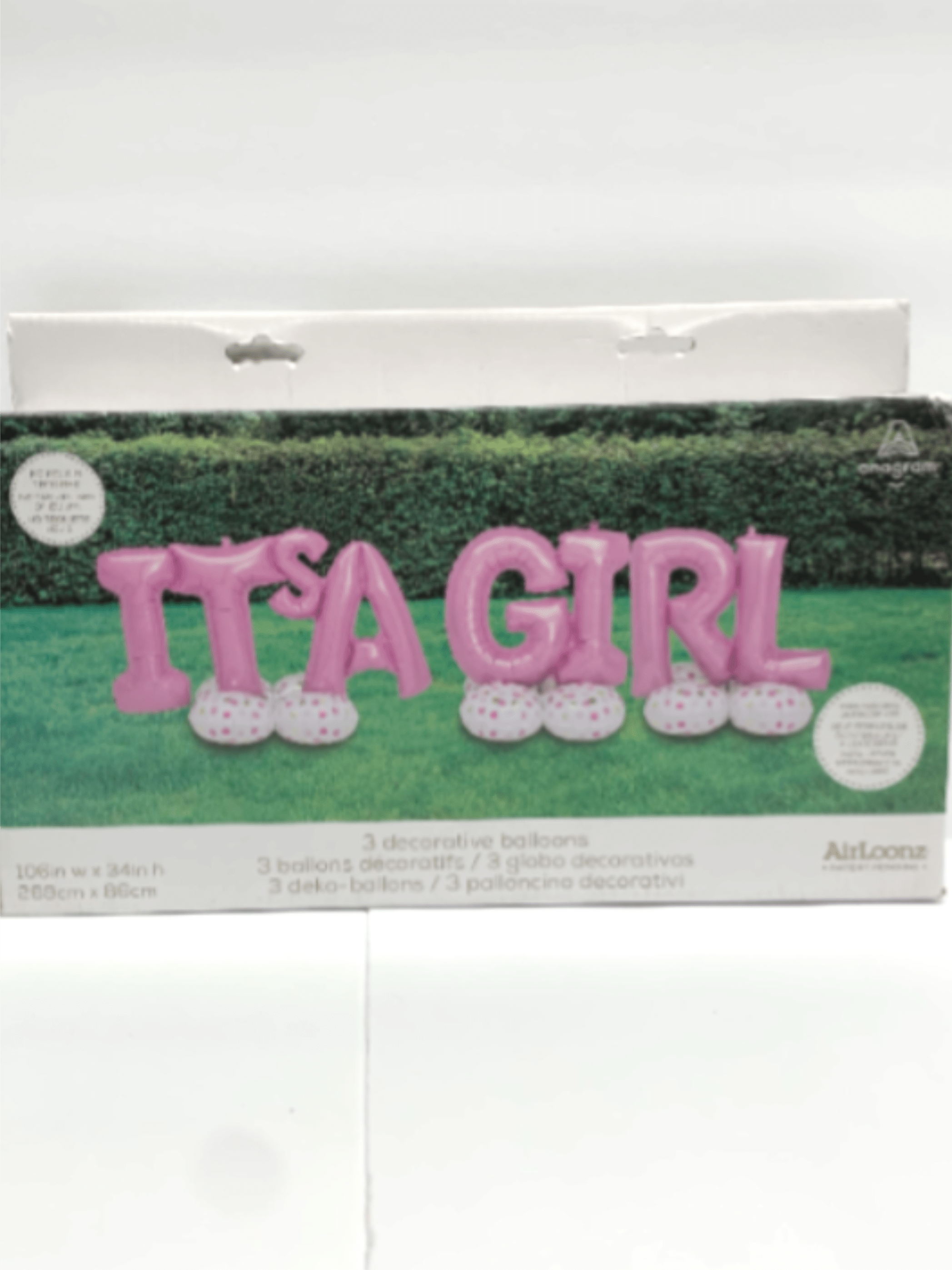 Boxed set of pink 'It's a Girl' letter balloons with white polka-dot bases on a grassy background
