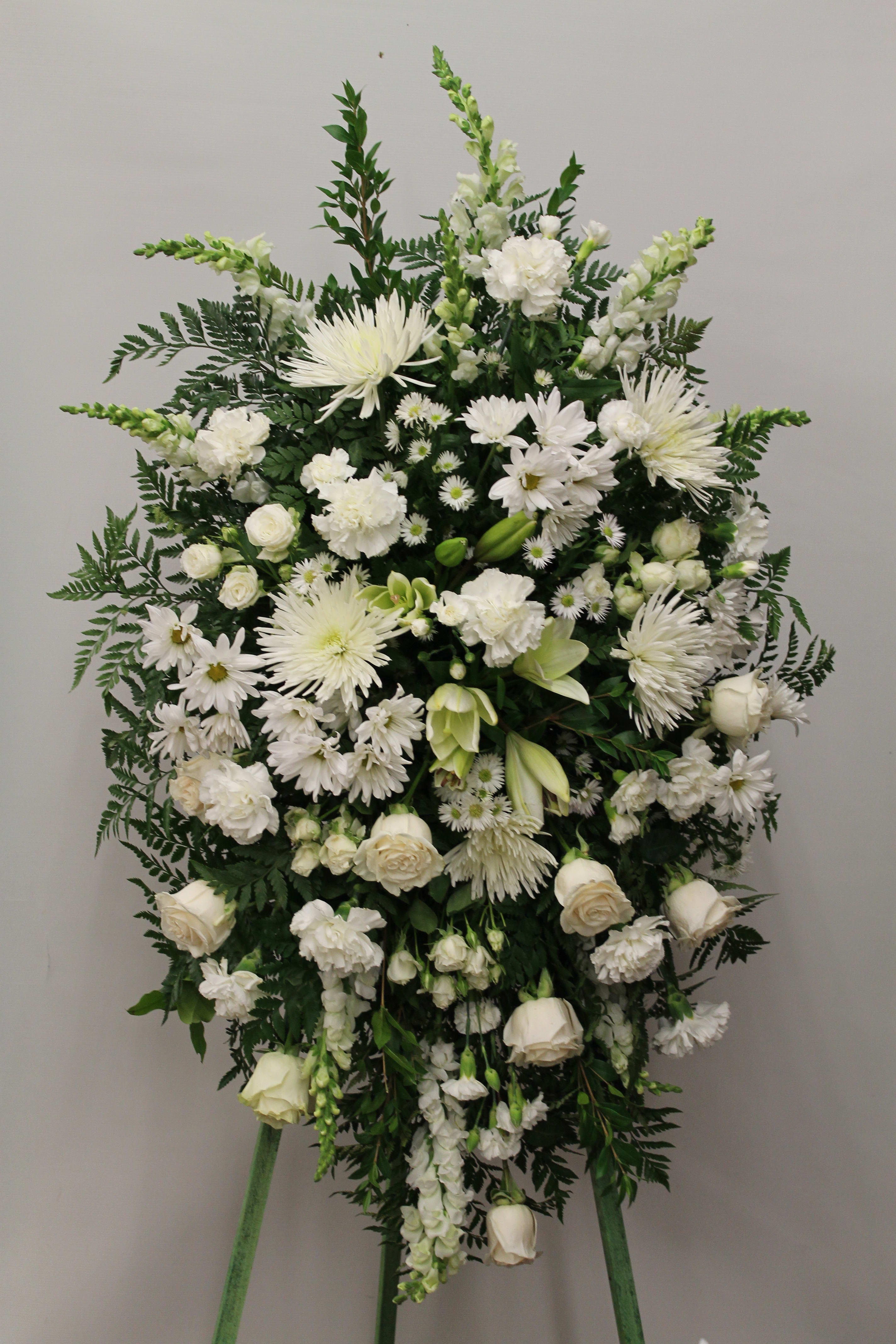 Large white funeral spray with roses, chrysanthemums, and lilies