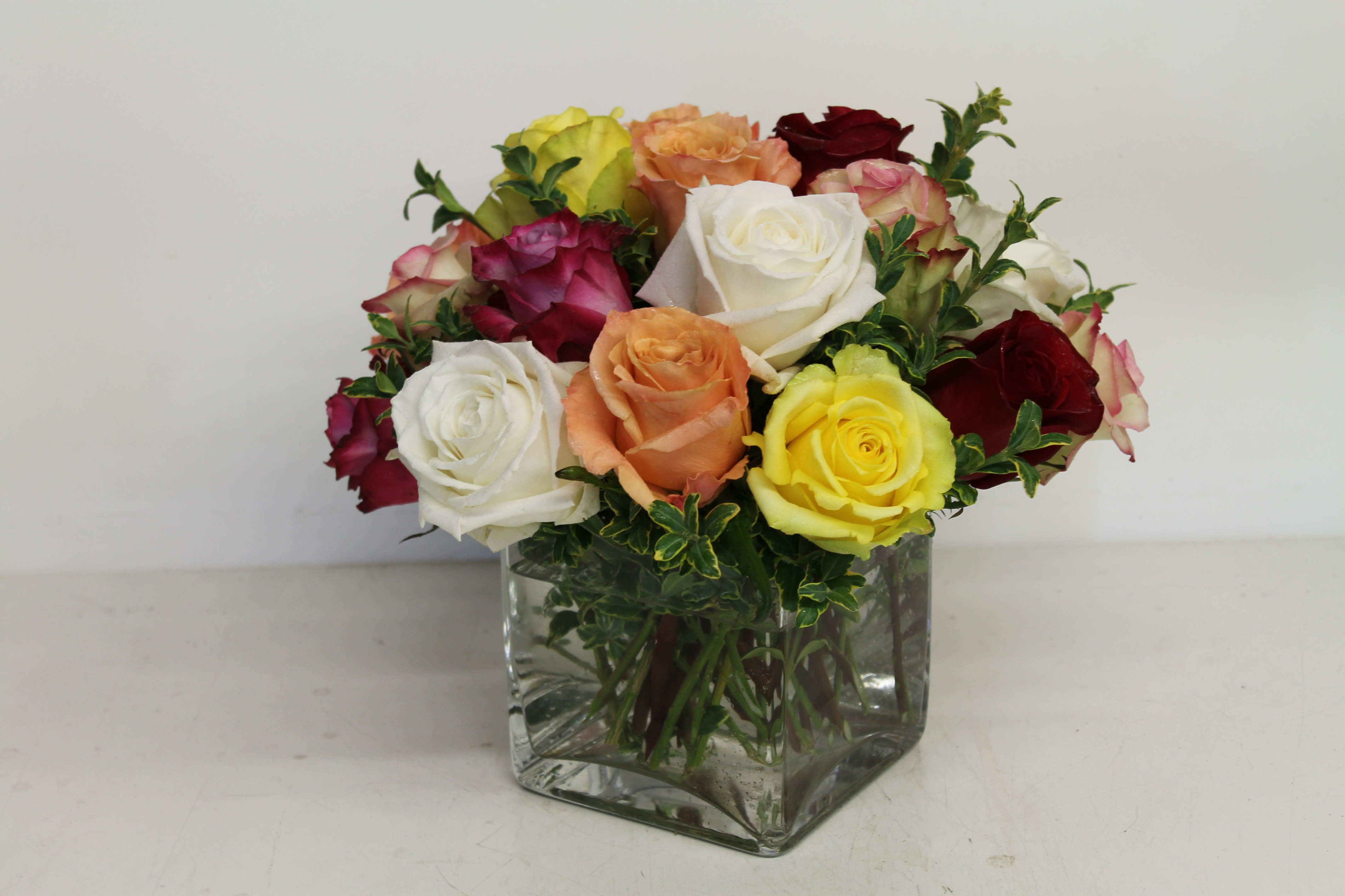 Mixed roses in a square glass vase