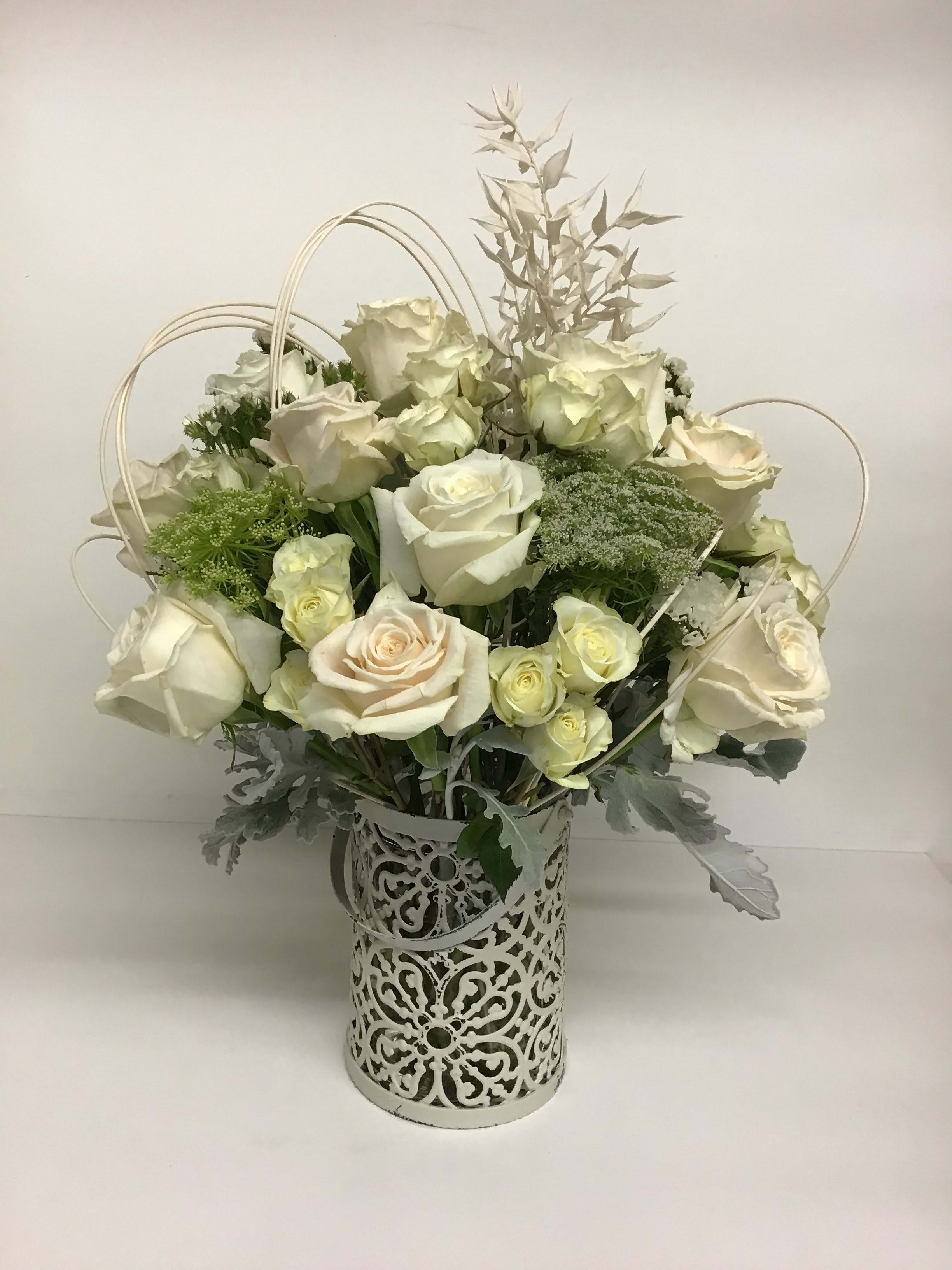 White rose arrangement in a decorative metal vase