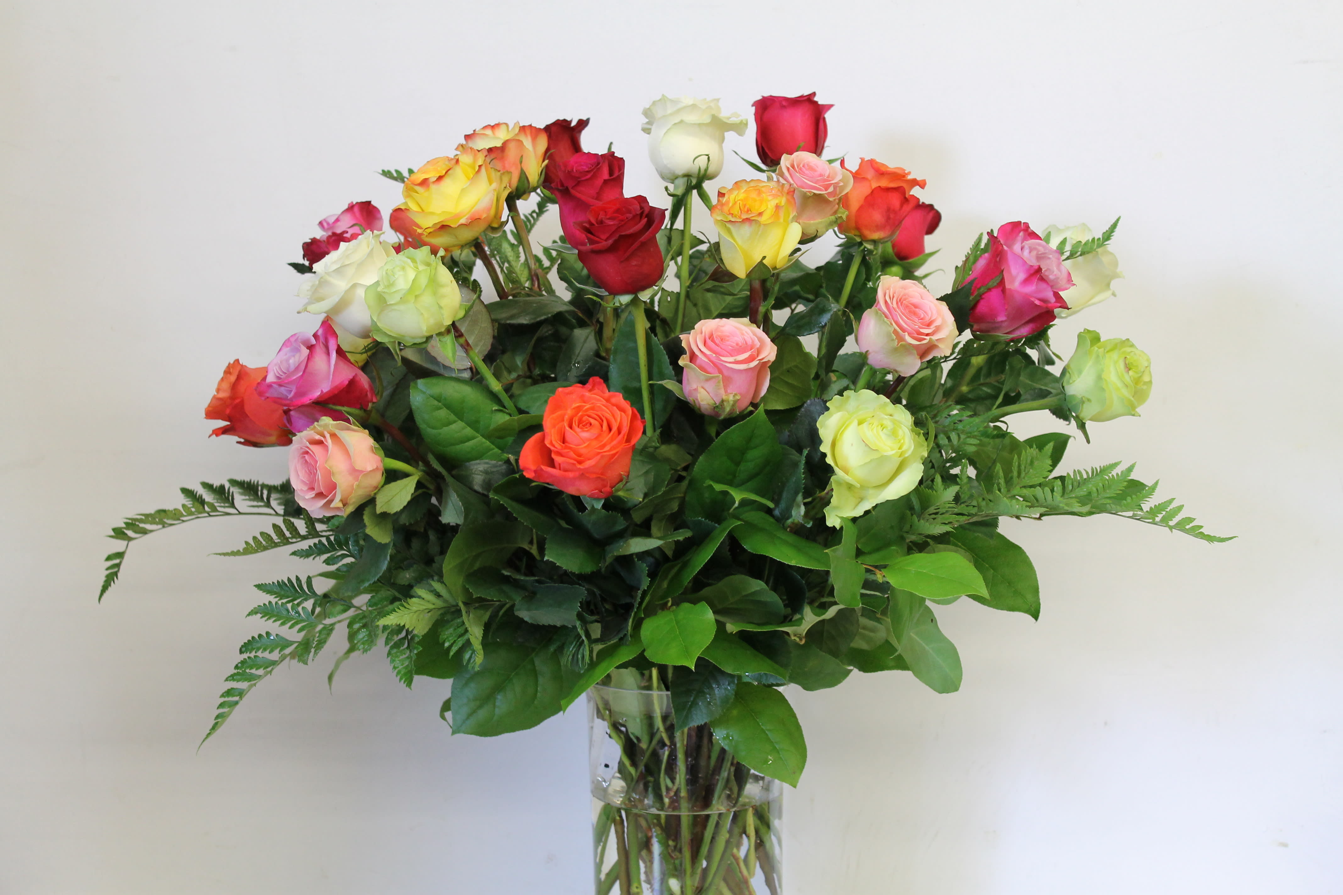 Mixed-color roses arranged in a clear glass vase
