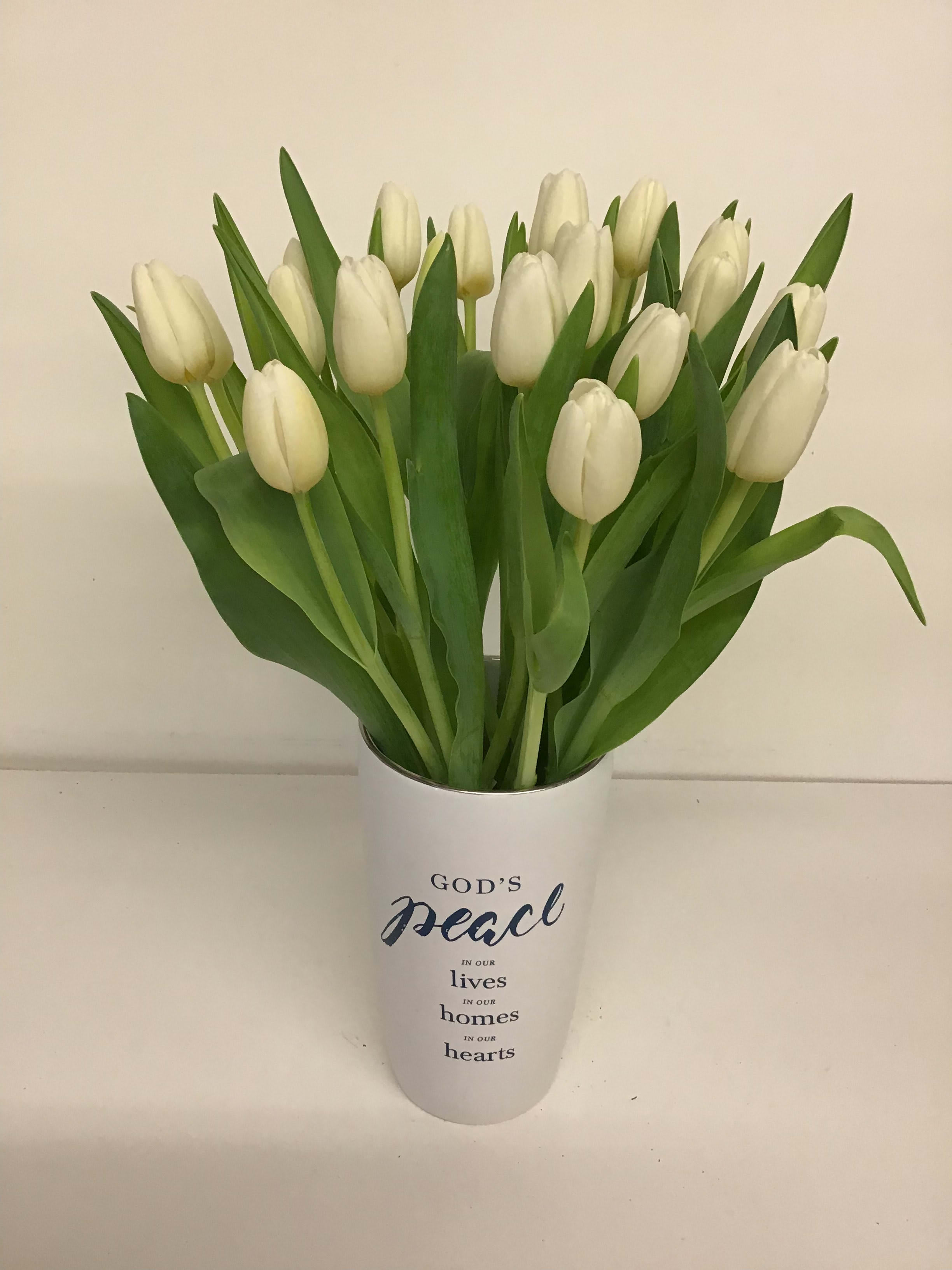 White tulips in a white vase with a peace message