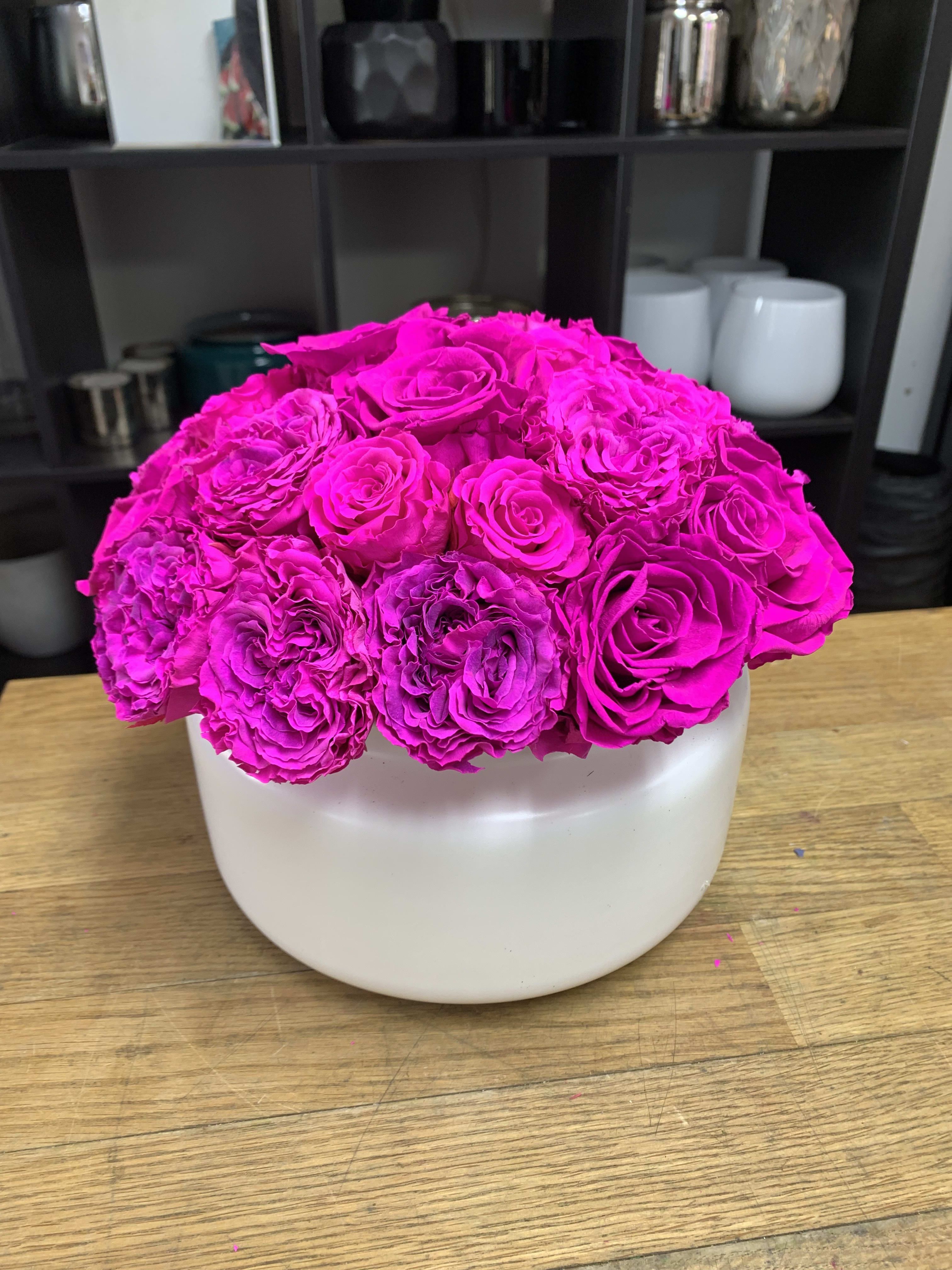 Hot pink roses arranged in a white round vase