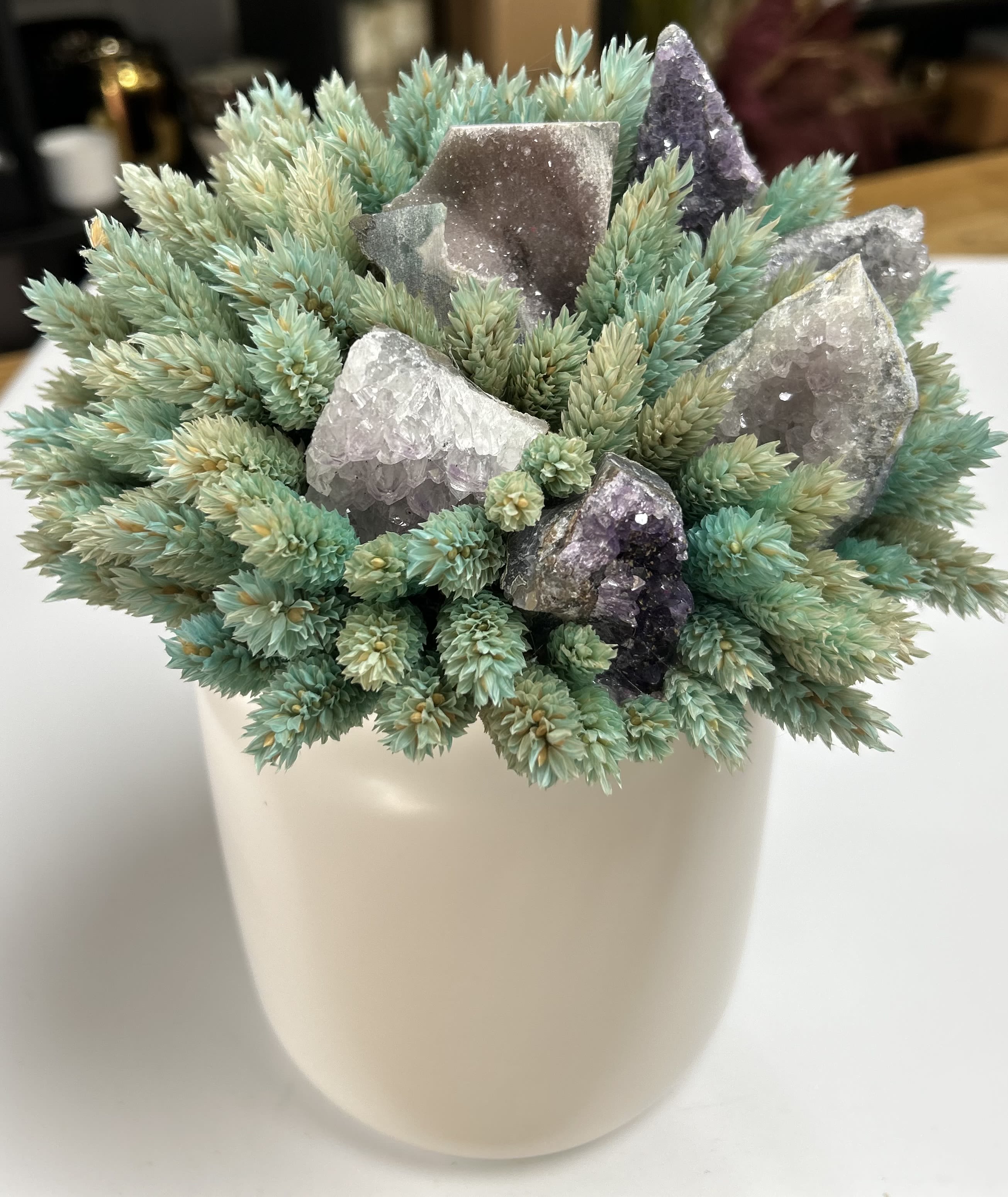 Potted succulent arrangement with crystal clusters in a white container