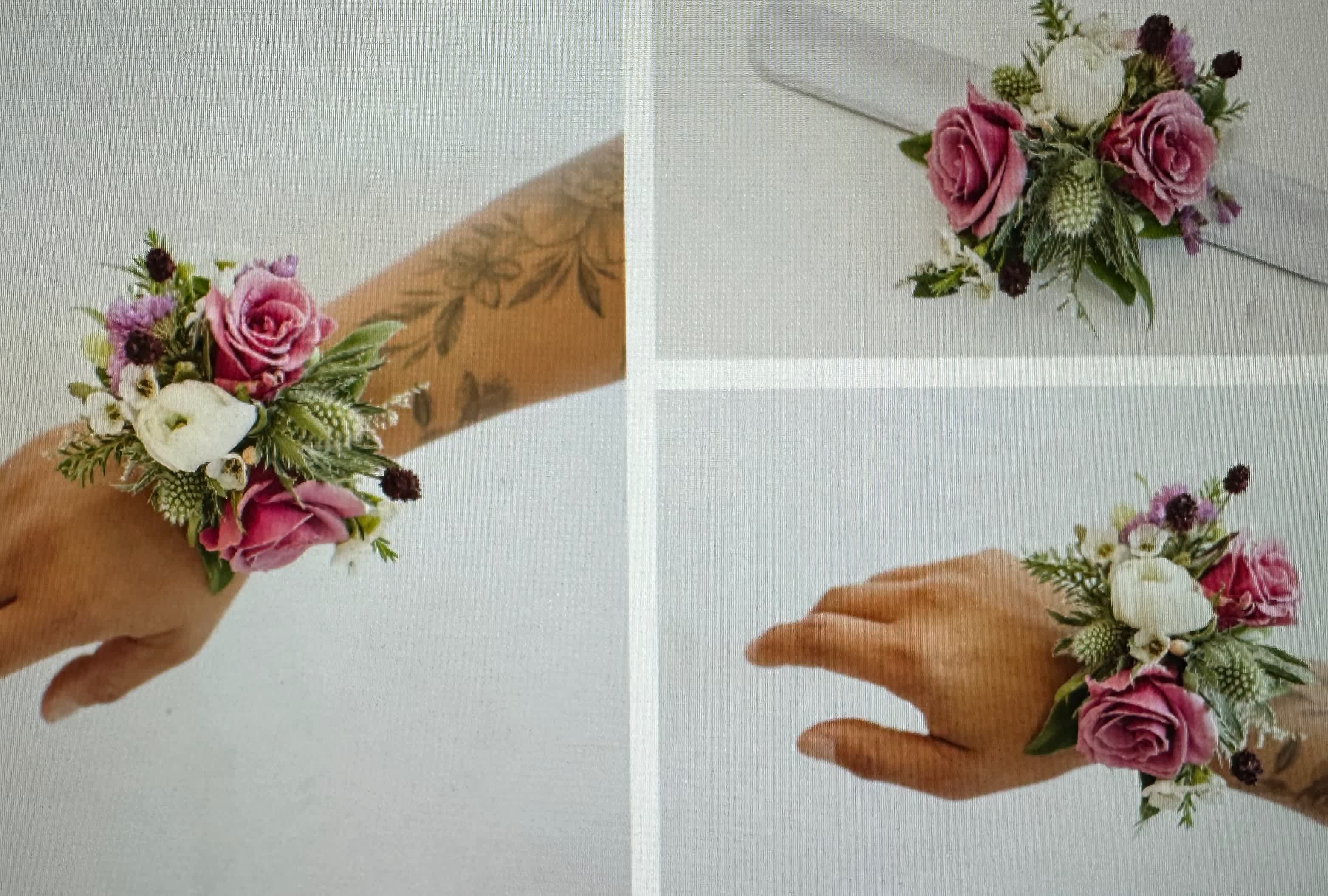 Wrist corsage with pink roses, white flowers, and greenery on a white ribbon band