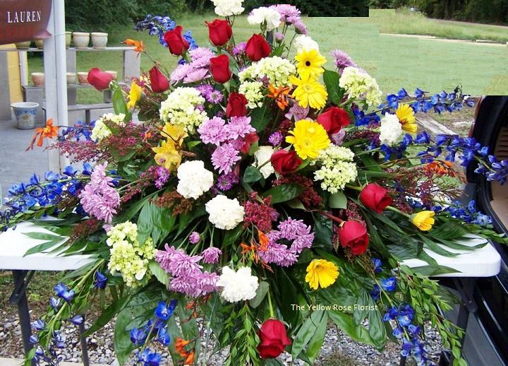 Large mixed floral spray with red roses, yellow daisies, and purple blooms