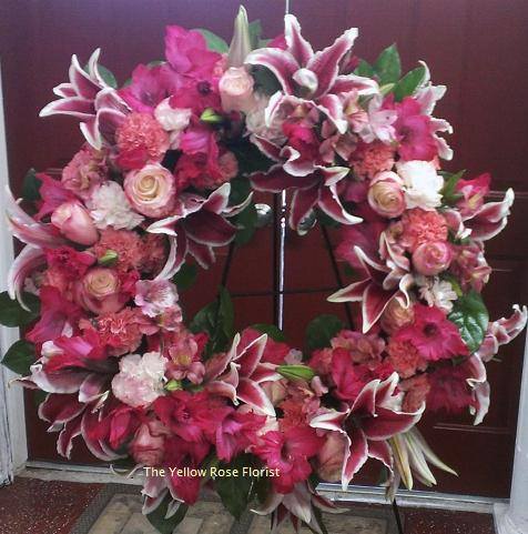 Rose and Lily Wreath - A beautiful wreath to celebrate the life lived of a love one.  Comes on a 15" base wreath or 21" base wreath displayed on a 60" easel