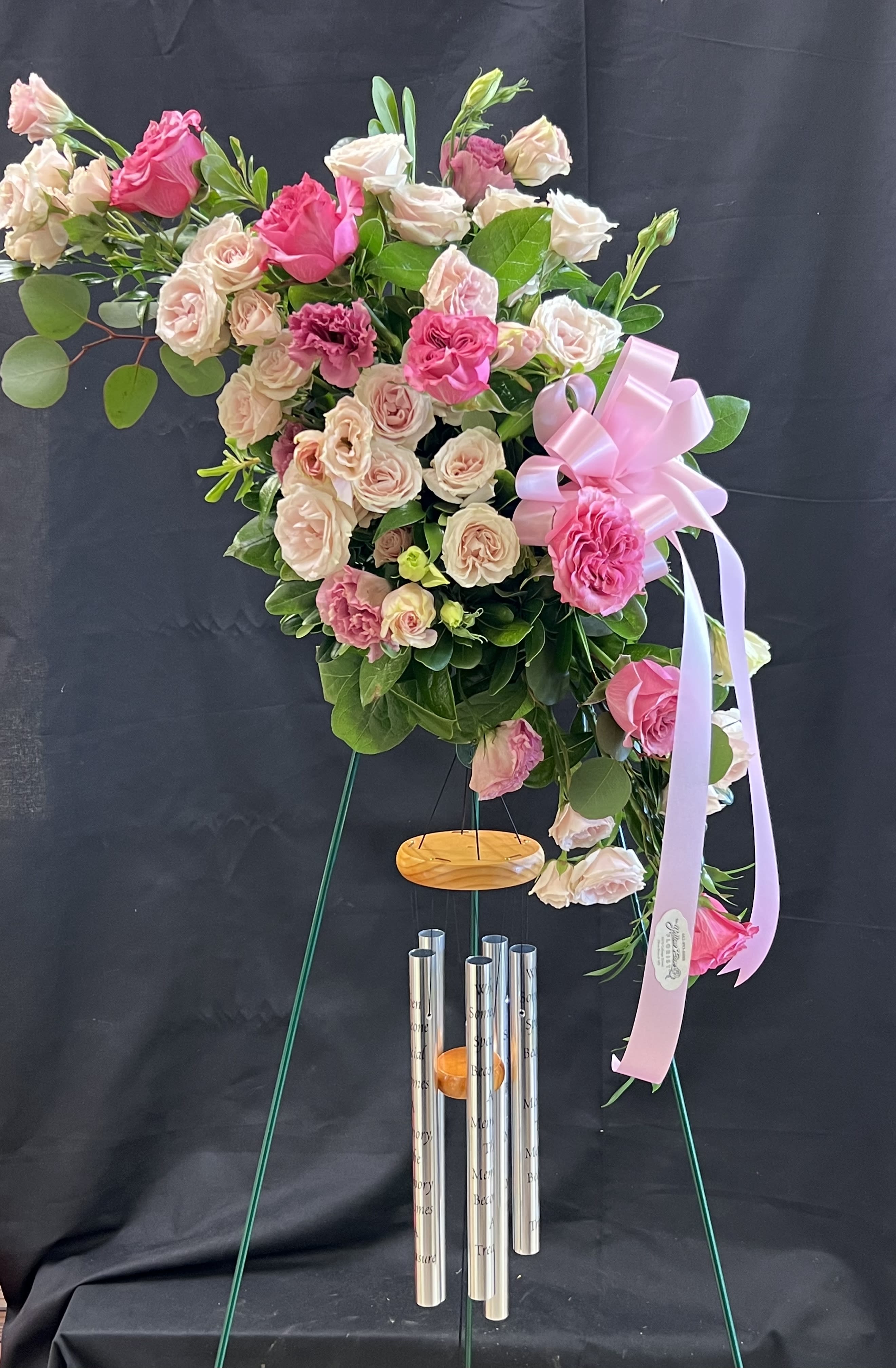Pink and blush rose arrangement on a stand with a ribbon bow