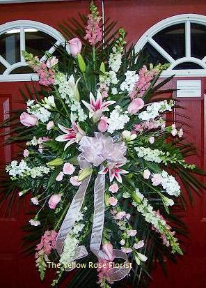 Large pink and white funeral spray with lilies and ribbon