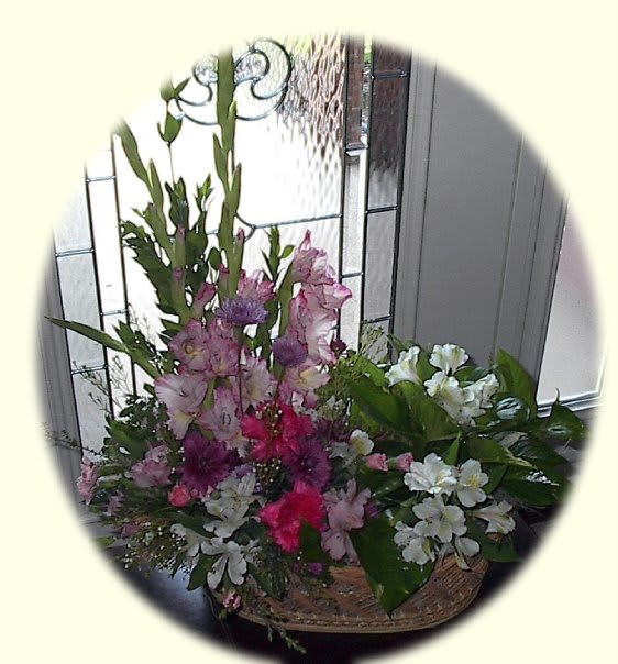 The Enchanted Garden - A beautiful fresh cut arrangement with a beautiful green plant all nestled together in one of our stained wicker baskets. Makes the perfect gift for any occasion.