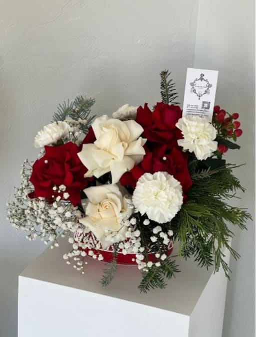 Red and white rose bouquet with carnations and evergreen accents
