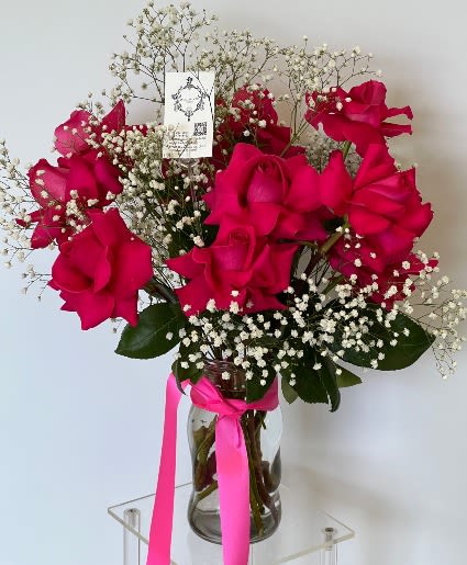 Bouquet of hot pink roses with baby's breath in a glass vase
