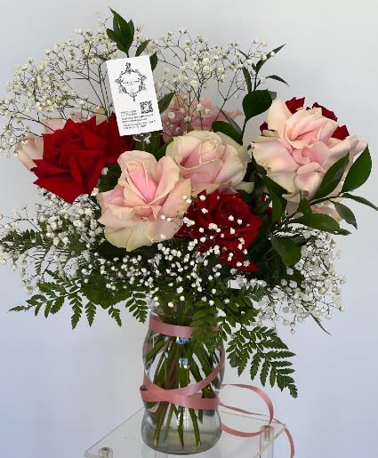 Pink and red roses in a glass vase with baby's breath